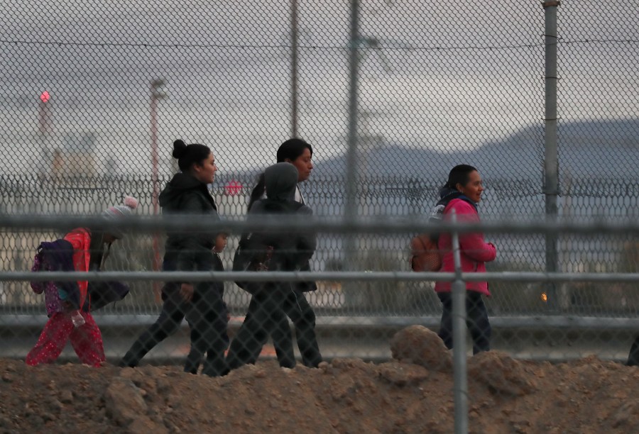 Migrants walk along the U.S.- Mexico border wall as they make their way to U.S. Border Patrol on Feb. 10, 2019 in El Paso, Texas. (Credit: Joe Raedle/Getty Images)