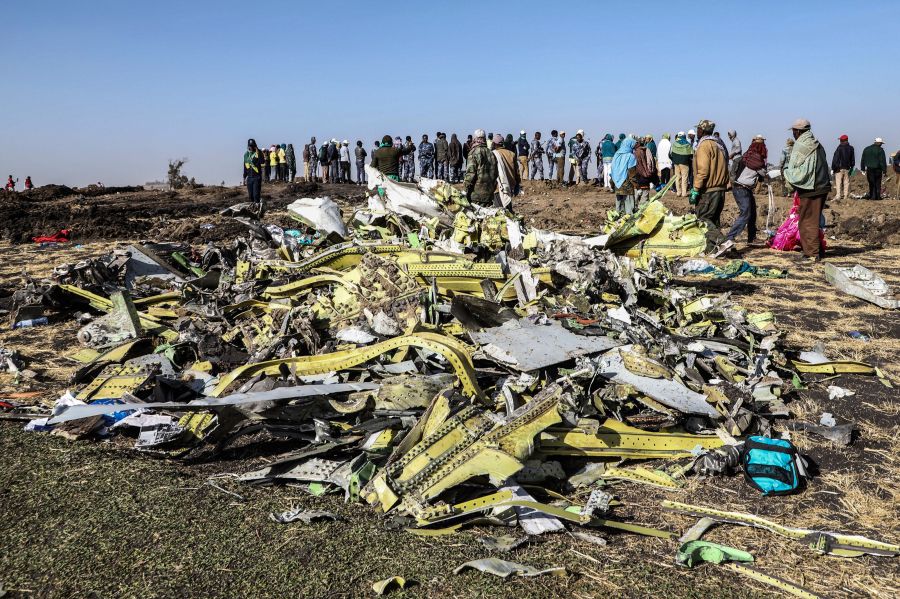 People stand near collected debris at the crash site of Ethiopia Airlines near Bishoftu, a town some 60 kilometres southeast of Addis Ababa, Ethiopia, on March 11, 2019. (Credit: MICHAEL TEWELDE/AFP/Getty Images)