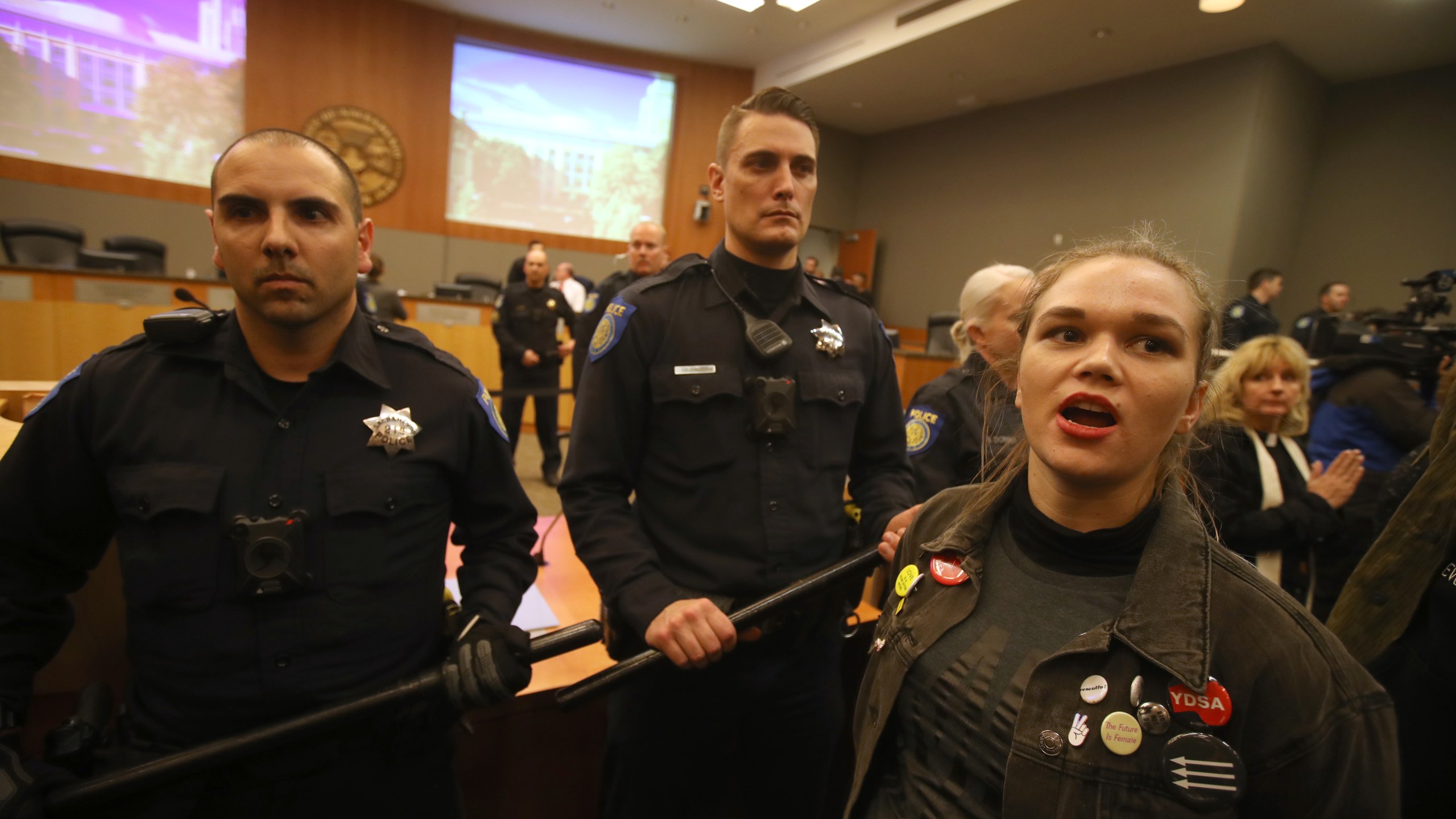 Sacramento police officers guard the dais as activists disrupt a Sacramento City Council meeting on March 5, 2019. (Credit: Justin Sullivan / Getty Images)