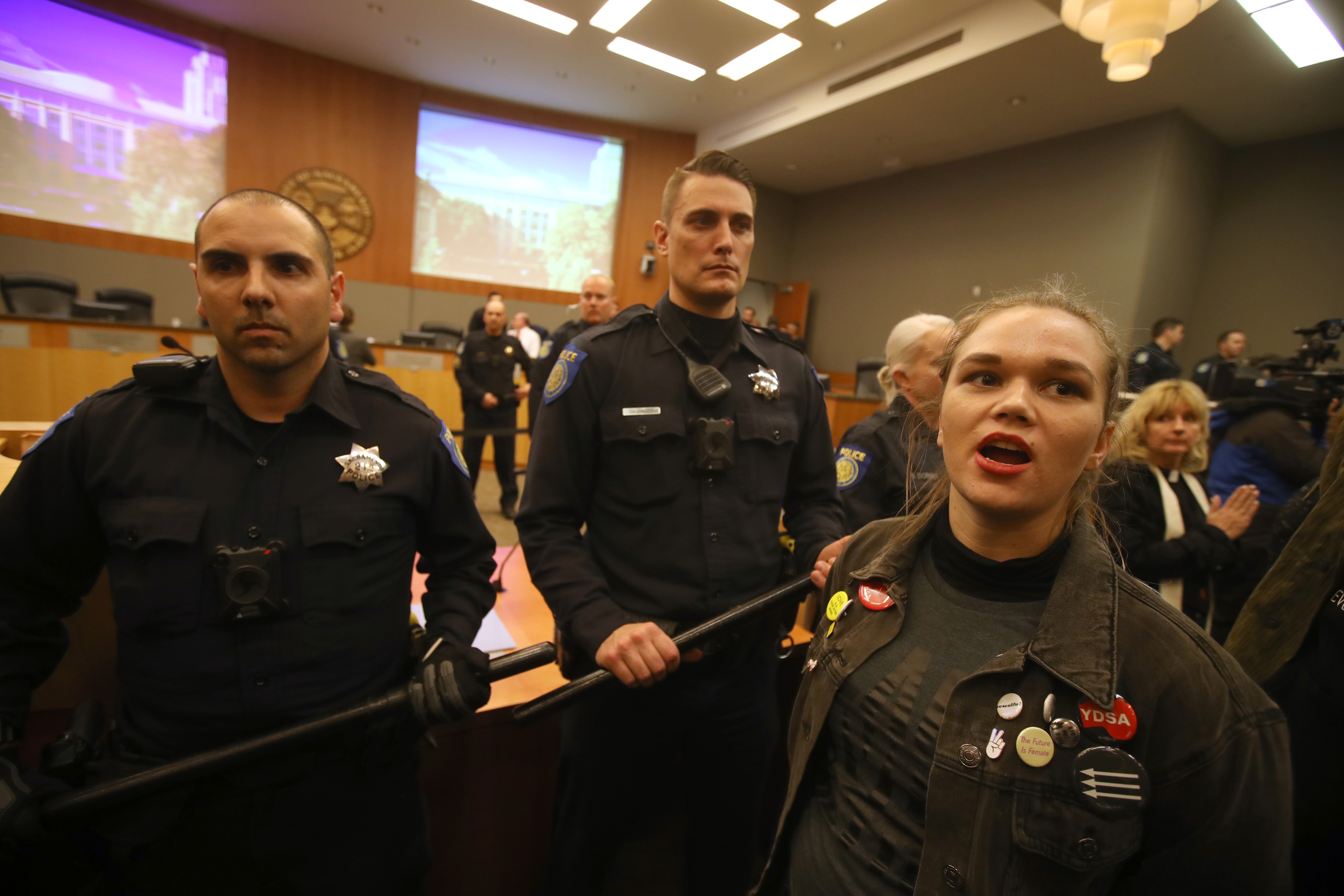 Sacramento police officers guard the dais as activists disrupt a Sacramento City Council meeting on March 5, 2019. (Credit: Justin Sullivan / Getty Images)