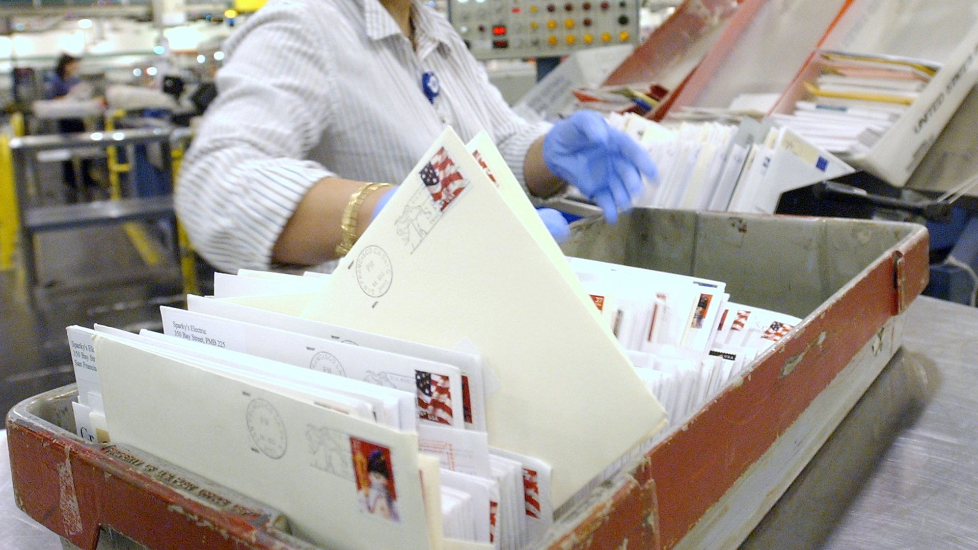 A U.S. Postal worker sorts mail at the San Francisco Processing and Distribution Center on Dec. 16, 2002, in San Francisco. (Credit: Justin Sullivan/Getty Images)