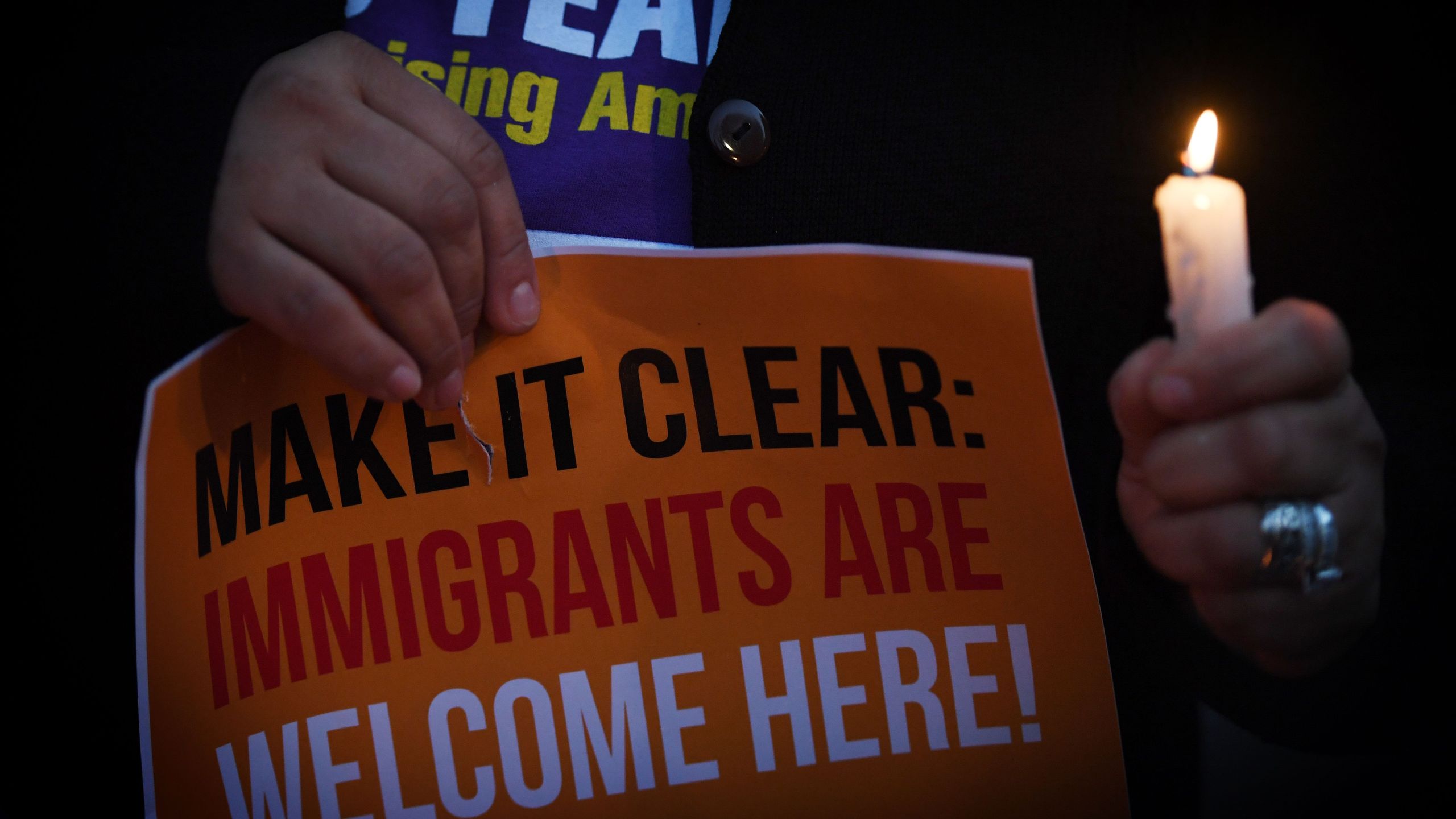 Migrant rights groups hold candles during a vigil to protest against Donald Trump's crackdown on "sanctuary cities" outside the City Hall in Los Angeles on Jan. 25, 2017.