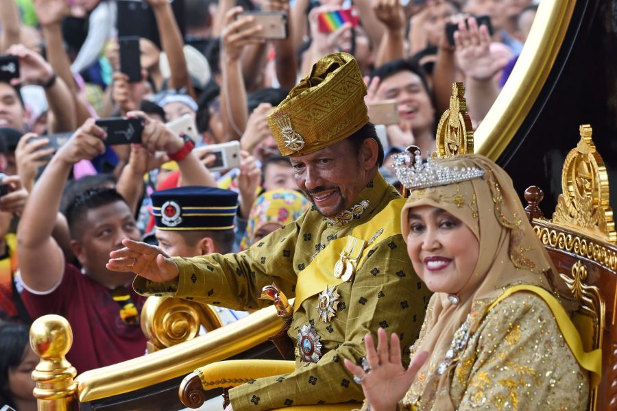 Brunei's Sultan Hassanal Bolkiah and Queen Saleha ride in a royal chariot during a procession to mark his golden jubilee of accession to the throne in Bandar Seri Begawan on October 5, 2017. (Credit: Roslan Rahman/AFP/Getty Images)