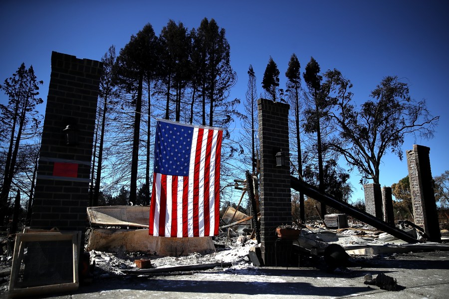 An American flag hangs in front of a home in the Coffey Park neighborhood that was destroyed by the Tubbs Fire on Oct. 23, 2017, in Santa Rosa. (Credit: Justin Sullivan/Getty Images)