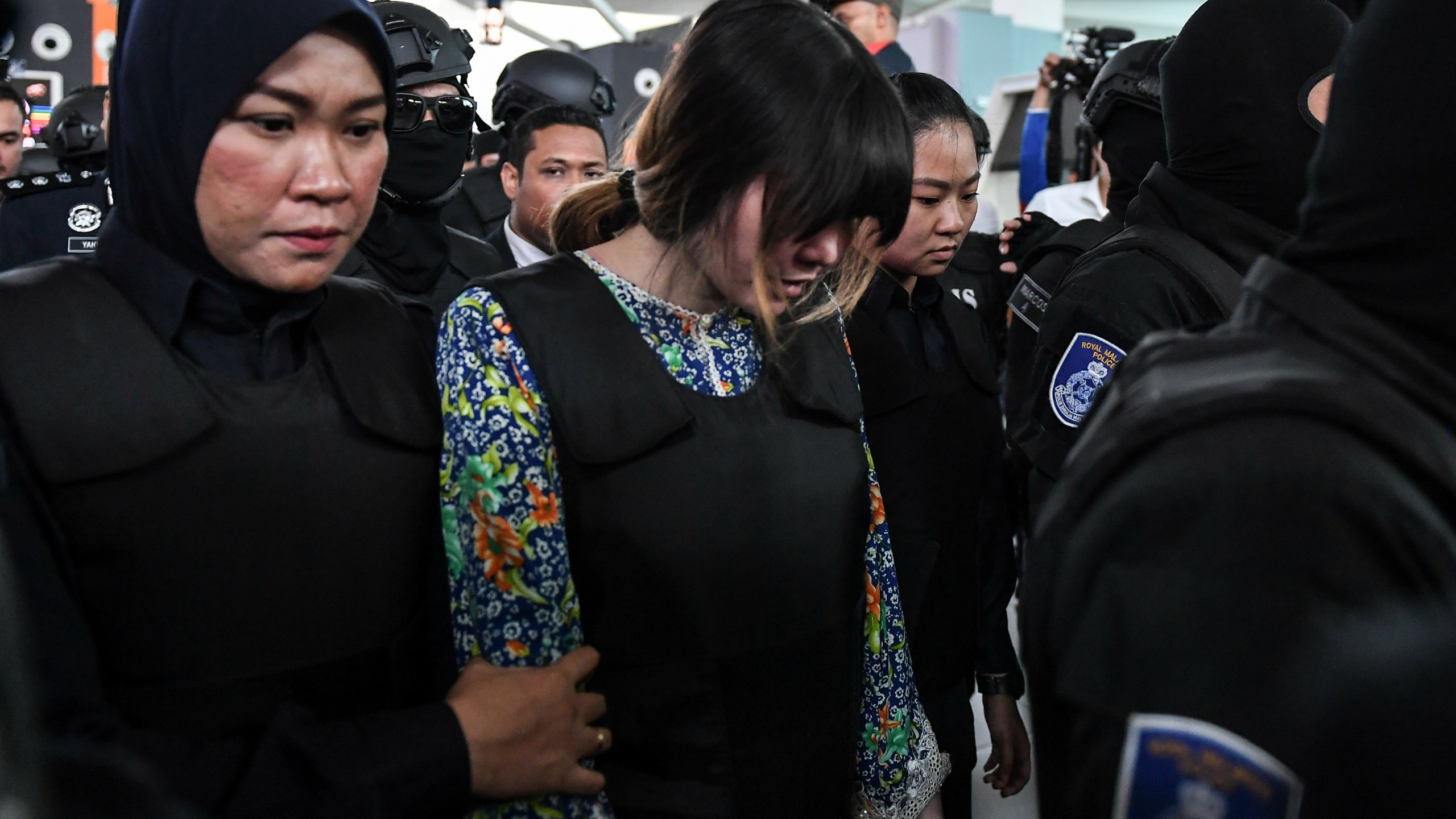 Vietnamese defendant Doan Thi Huong (C) is escorted by police personnel towards the low-cost carrier Kuala Lumpur International Airport 2 (KLIA2) in Sepang during a visit to the scene of the murder as part of the Shah Alam High Court trial process on October 24, 2017, for her alleged role in the assassination of Kim Jong-Nam. (Credit: Mohd Rasfan/AFP/Getty Images)