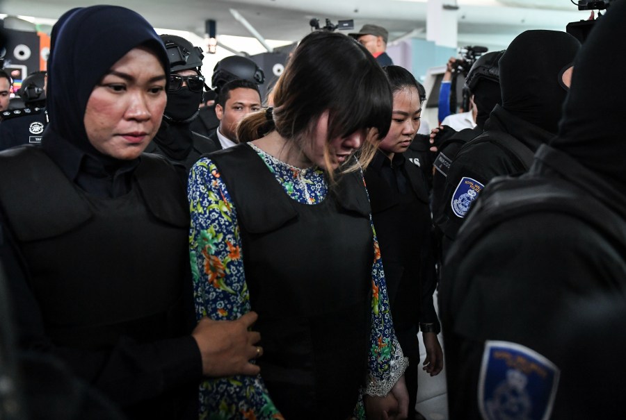 Vietnamese defendant Doan Thi Huong (C) is escorted by police personnel towards the low-cost carrier Kuala Lumpur International Airport 2 (KLIA2) in Sepang during a visit to the scene of the murder as part of the Shah Alam High Court trial process on October 24, 2017, for her alleged role in the assassination of Kim Jong-Nam. (Credit: Mohd Rasfan/AFP/Getty Images)