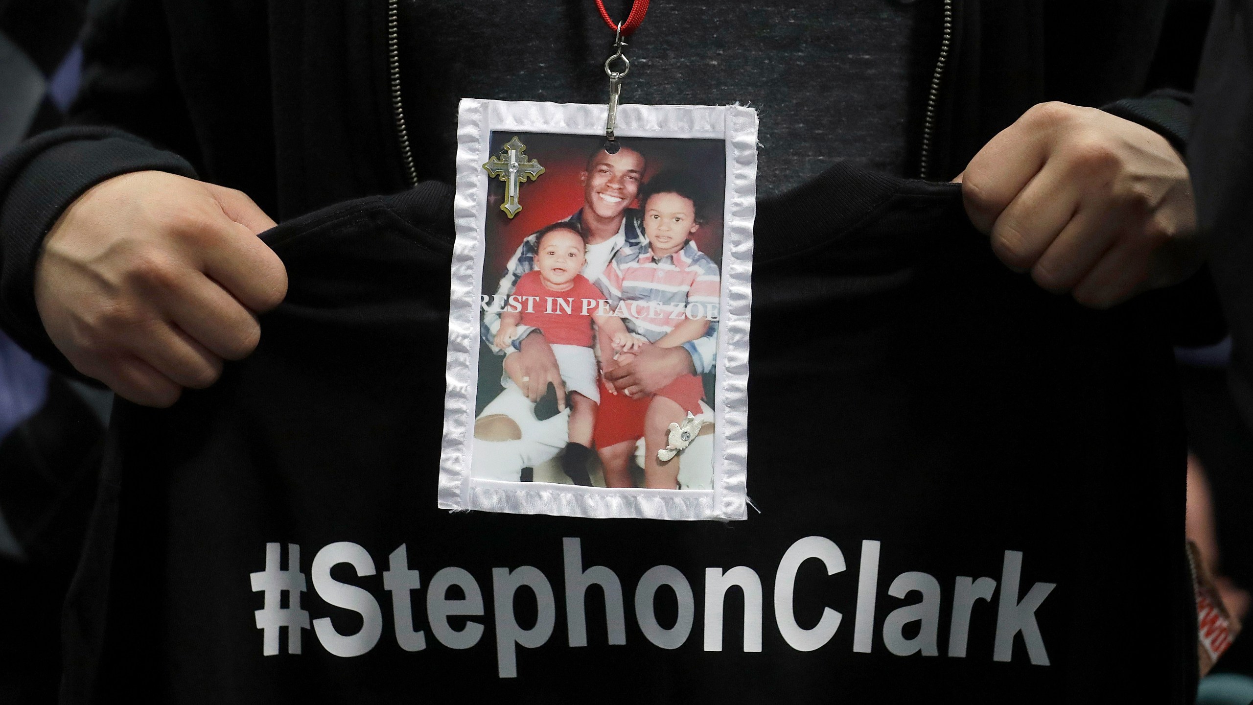 A mourner holds up a photo of police shooting victim Stephon Clark during funeral services at the Bayside Of South Sacramento Church March 29, 2018 in Sacramento. (Credit: Jeff Chiu-Pool/Getty Images)