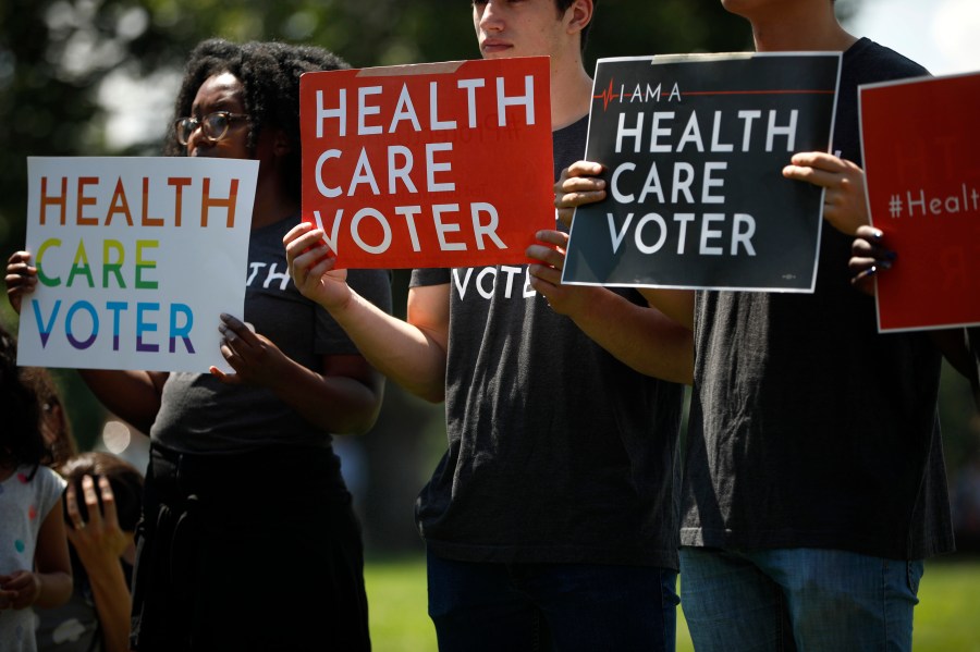 Demonstrators hold signs as Democratic leaders speak with reporters outside the U.S. Capitol June 26, 2018 in Washington, D.C. (Credit: Aaron P. Bernstein/Getty Images)