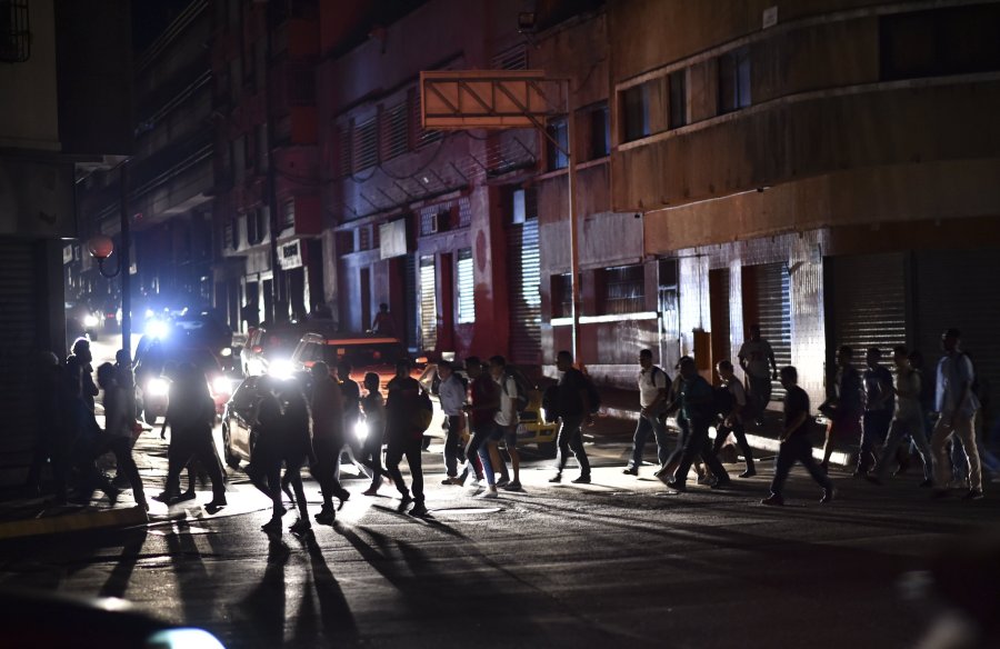 People cross a street during a power cut in Caracas, Venezuela, on March 7, 2019. (Credit: Yuri Cortez/AFP/Getty Images)