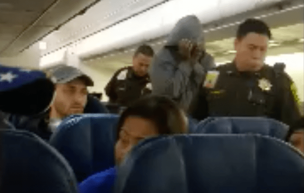 Officials escort a Hawaiian Airlines passenger off the plane in Honolulu on March 19, 2019. (Credit: Derek Smiling)