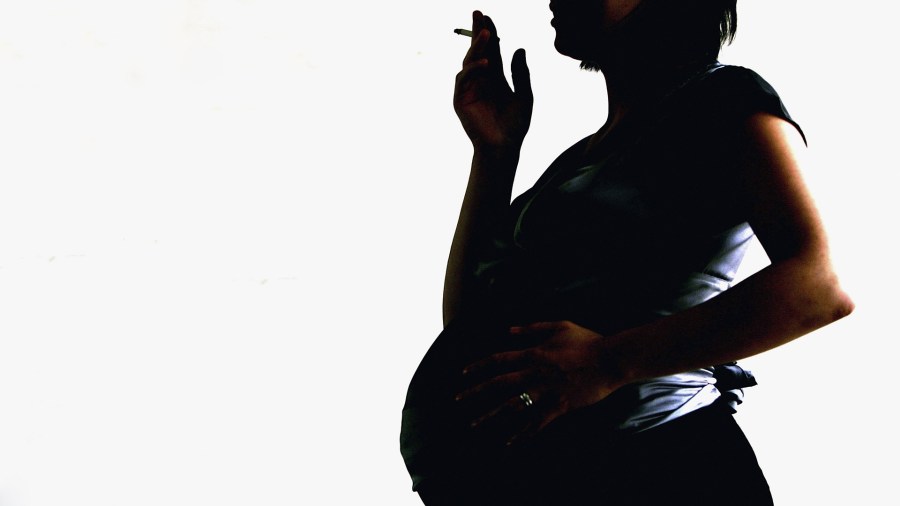 In this photo illustration a pregnant woman is seen holding a cigarette on July 18, 2005 in London, England. (Credit: Daniel Berehulak/Getty Images)