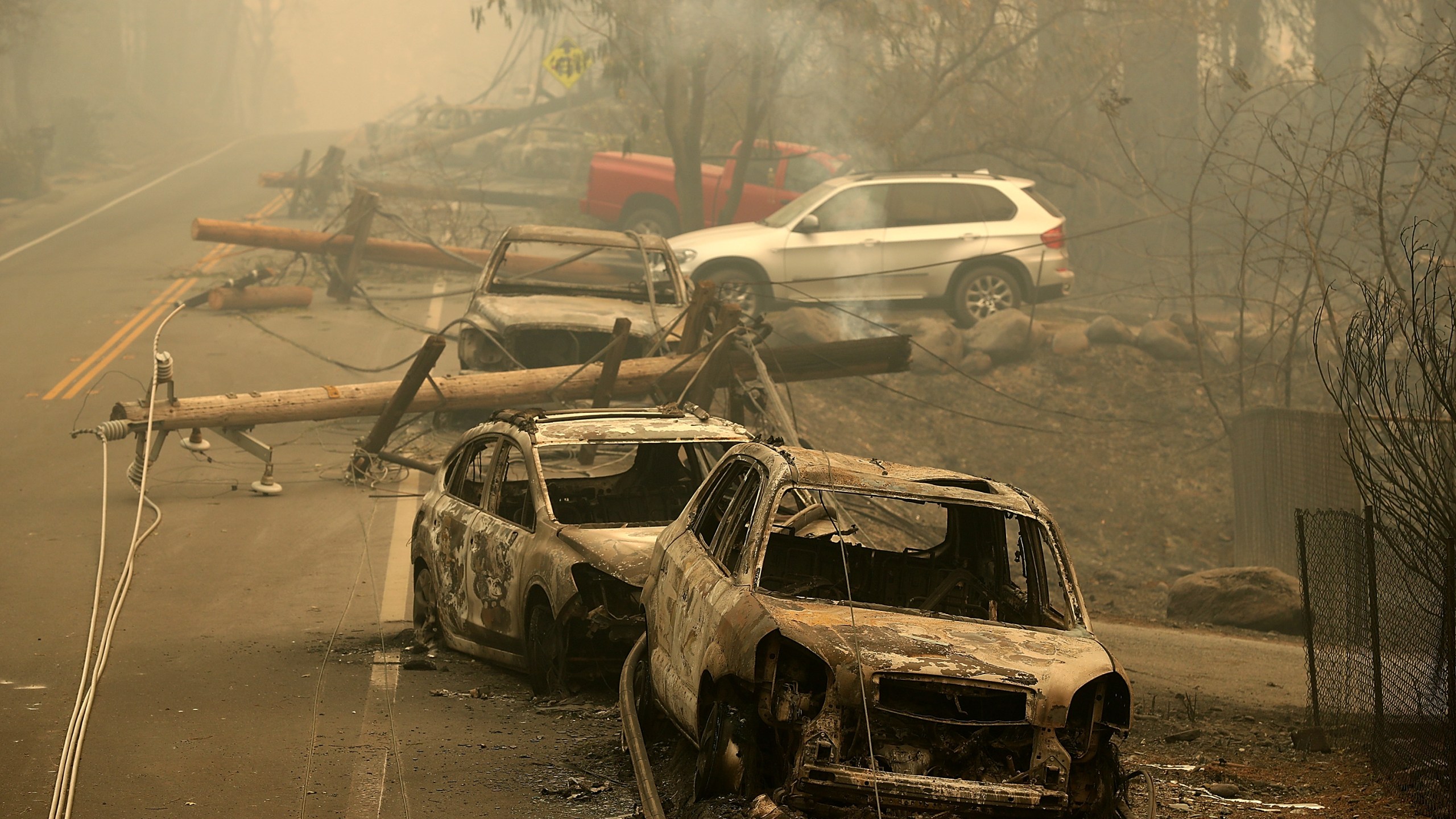 Power lines rest on cars that were burned by the Camp Fire on Nov. 10, 2018, in Paradise, Calif. (Credit: Justin Sullivan/Getty Images)