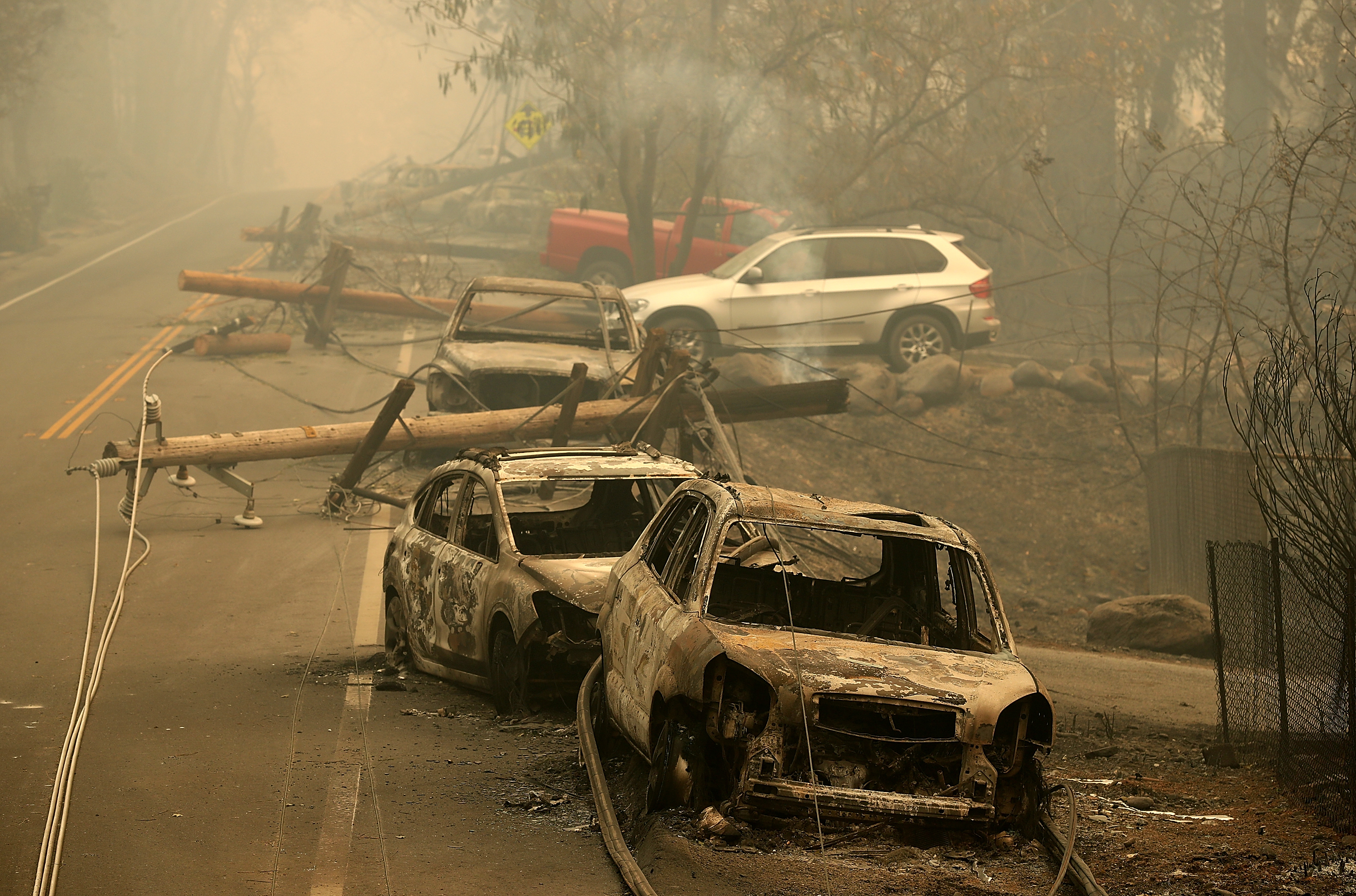 Power lines rest on cars that were burned by the Camp Fire on Nov. 10, 2018, in Paradise, Calif. (Credit: Justin Sullivan/Getty Images)