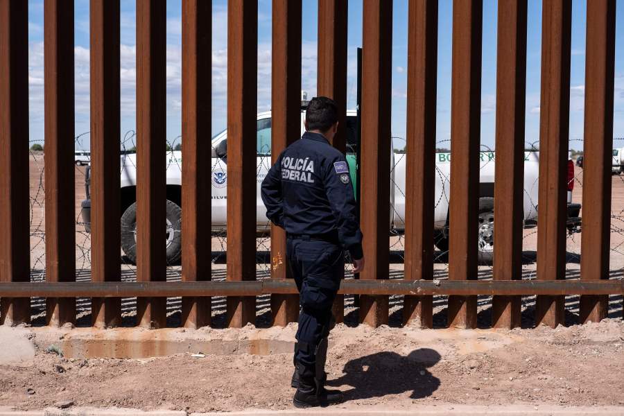 A Border patrol unit and a Mexican federal police guard stop near the U.S.-Mexico border fence in Calexico, California. (Credit: GUILLERMO ARIAS/AFP/Getty Images)