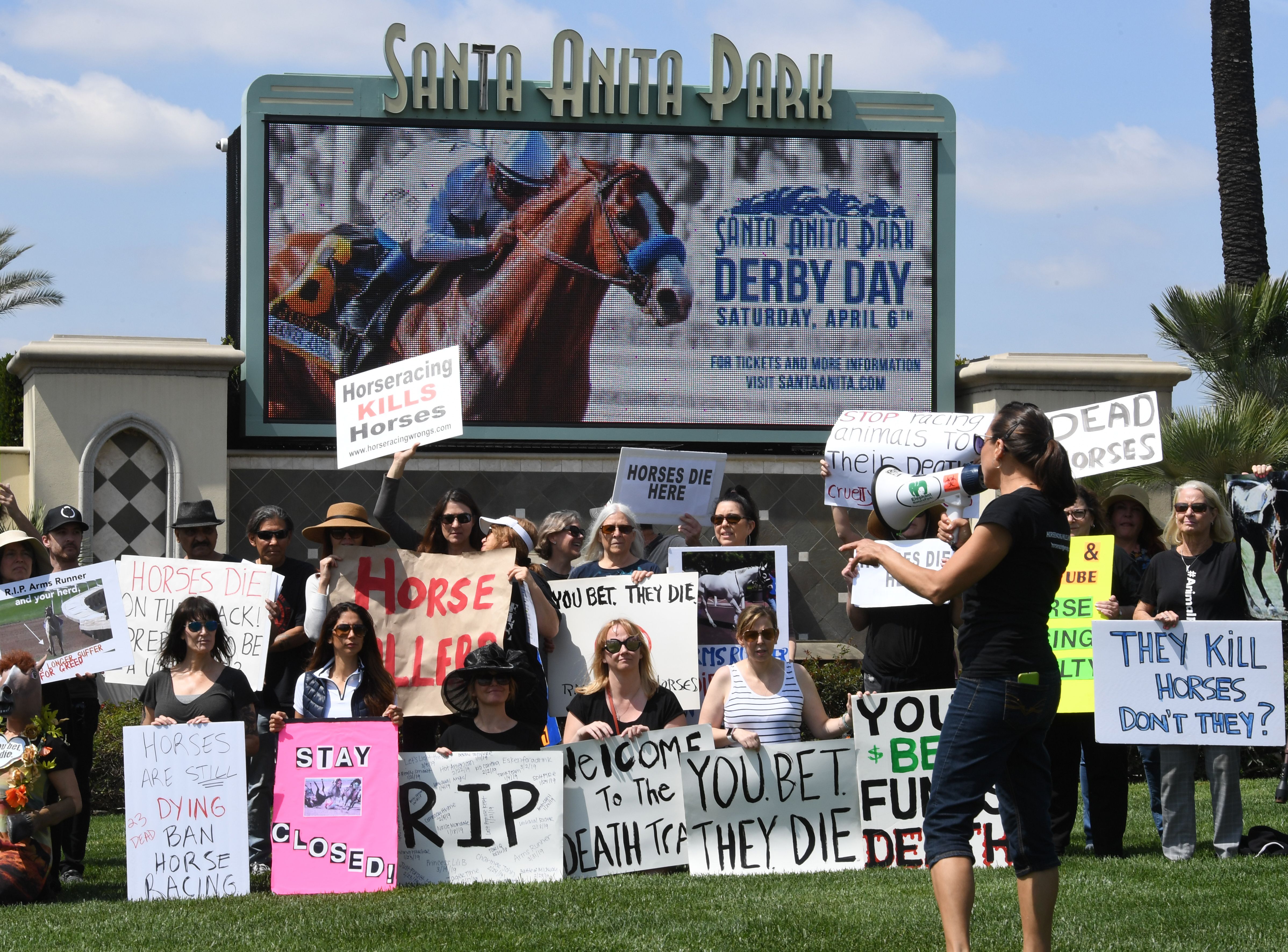 Animal-rights advocates protest beside the racetrack entrance gate after the deaths of 23 racehorses in the first three months of 2019 at the Santa Anita Park in Arcadia, April 6, 2019. (Credit: Mark Ralston / AFP / Getty Images)