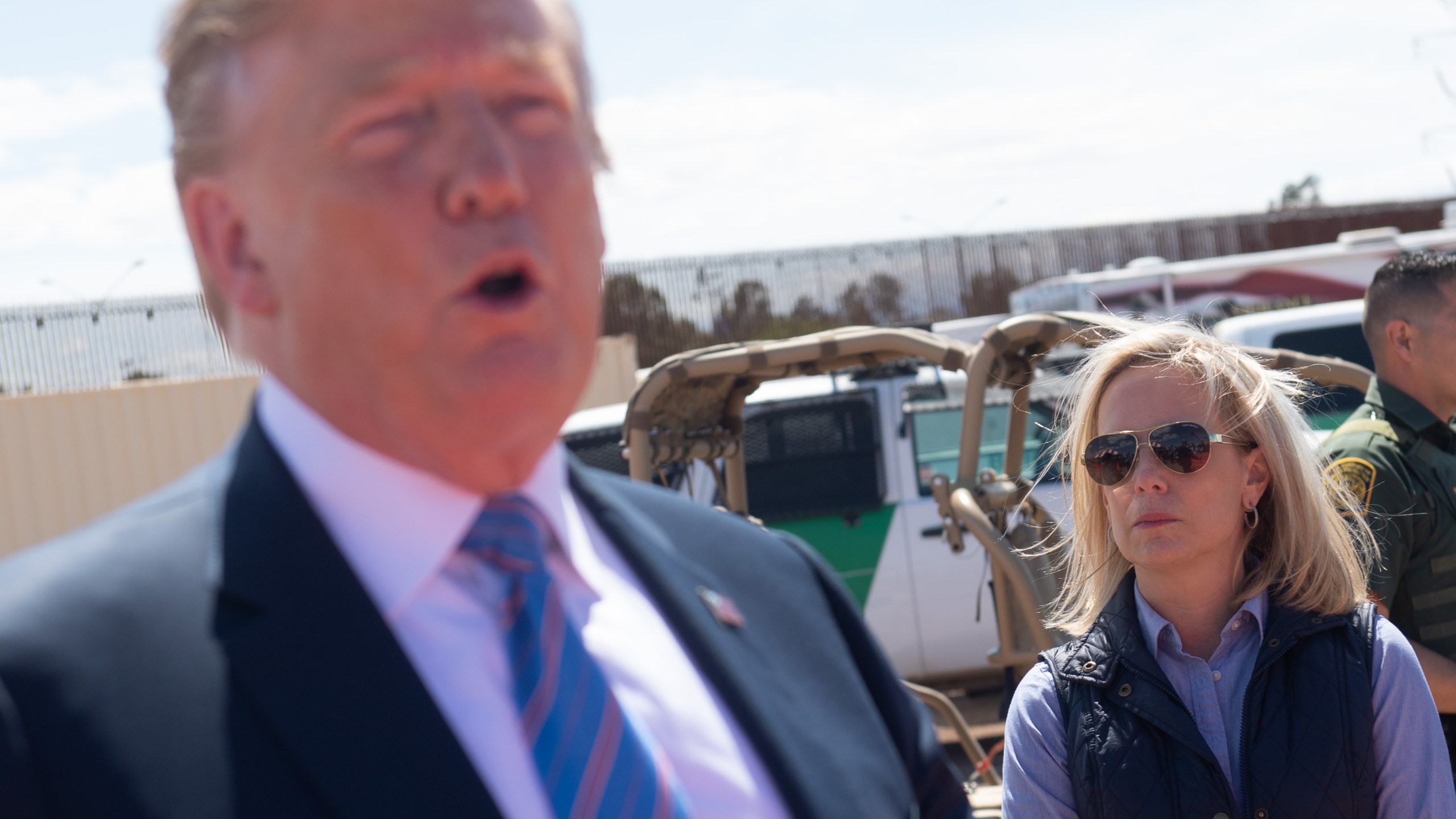 In this photo taken on April 5, 2019, Secretary of Homeland Security Kirstjen Nielsen stands alongside President Donald Trump as he tours the border wall in Calexico. (Credit: SAUL LOEB/AFP/Getty Images)