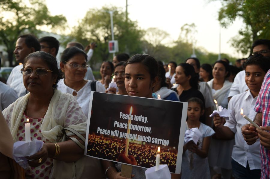 Indian Christians hold placards and candles as they participate in a peace march to show solidarity with the Sri Lankan victims of the last week's serial bombings in Ahmedabad on April 28, 2019. Sri Lanka's churches remained shuttered on April 28, 2019, forcing Christians to say prayers of grief in private over the Easter suicide attacks that the country's Roman Catholic leader called "an insult to humanity". (Credit: SAM PANTHAKY/AFP/Getty Images)