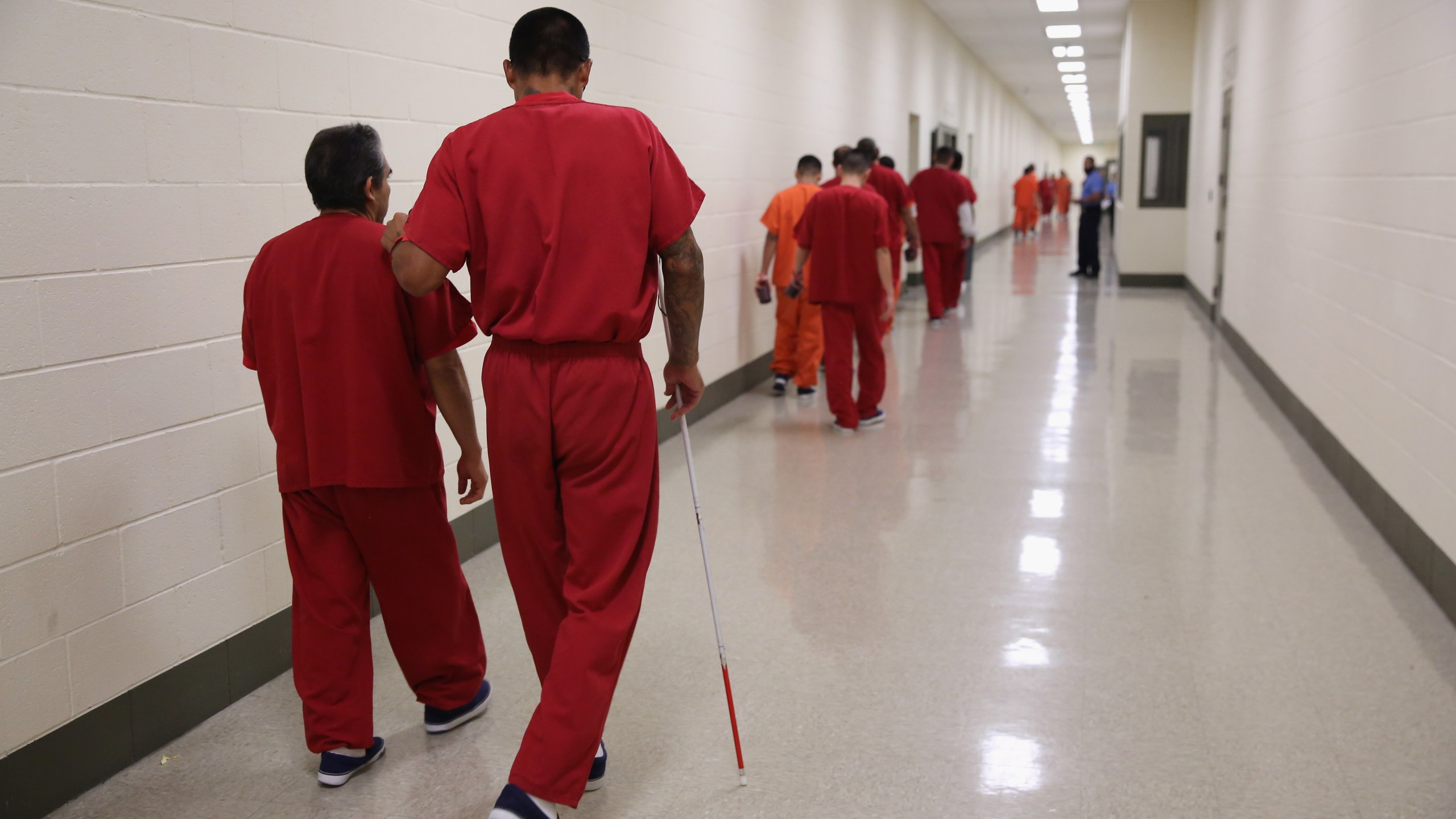 A blind detainee walks with a fellow immigrant at the Adelanto Detention Facility on Nov. 15, 2013 in Adelanto. (Credit: John Moore/Getty Images)