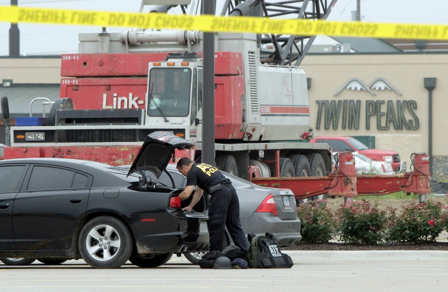 Law enforcement officials stands at the scene of a motorcycle gang shootout at the Twin Peaks restaurant in Waco, Texas, May 18, 2015. (Credit: Erich Schlegel / Getty Images)