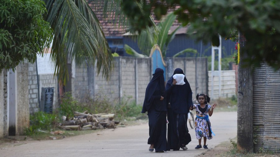 Sri Lankan Muslim women walk with a girl along a road in Kattankudy, Sri Lanka in an undated image. Credit: Lakruwan Wanniarchchi/Getty Images via CNN)