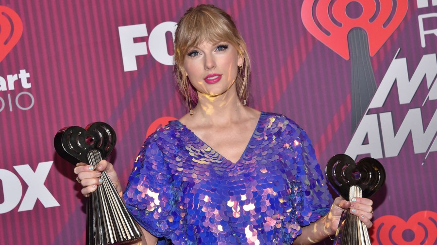 Taylor Swift poses in the press room with her awards for Tour of the Year and Best Music Video during the 2019 iHeart Radio Music Awards at the Microsoft theatre on March 14, 2019 in Los Angeles. (Credit: CHRIS DELMAS/AFP/Getty Images)