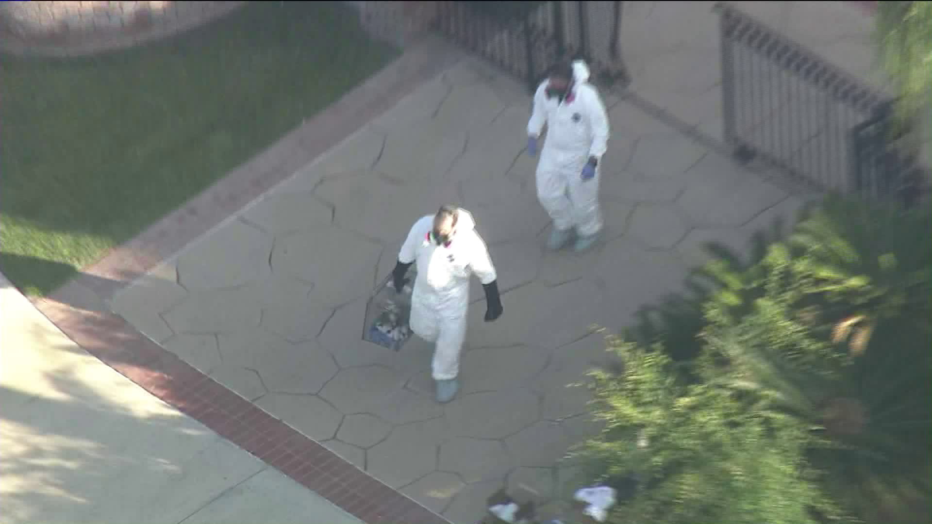 Officials donnned hazmat suits as they removed nearly 100 dogs from a home in the City of Orange on May 30, 2019. (Credit: KTLA)