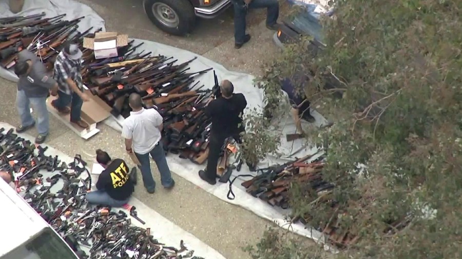 ATF agents and LAPD officers examine a massive weapons cache found at a Bel-Air home on May 8, 2019. (Credit: KTLA)