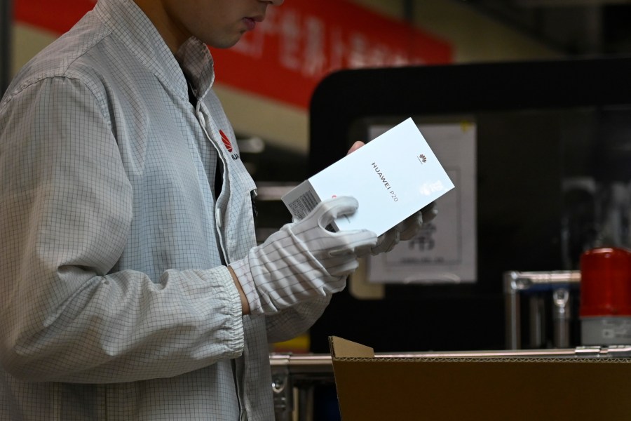 An employee works on a mobile phone production line at a Huawei production base during a media tour in Dongguan, China's Guangdong province on March 6, 2019. (Credit: WANG ZHAO/AFP/Getty Images)