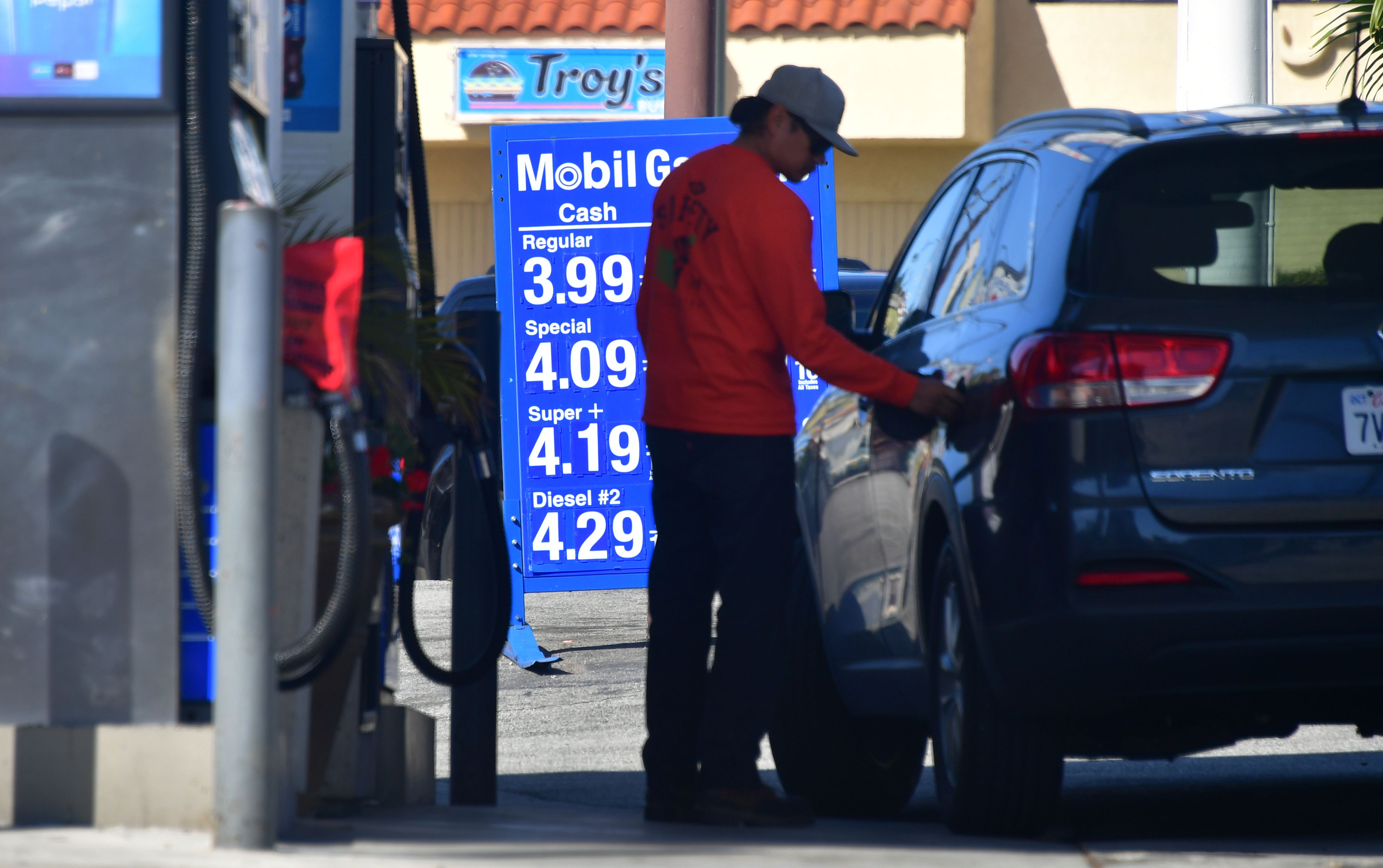 A driver closes the cap on his tank after filling up at a Los Angeles gas station on April 9, 2019. (Credit: Frederic J. Brown / AFP / Getty Images)