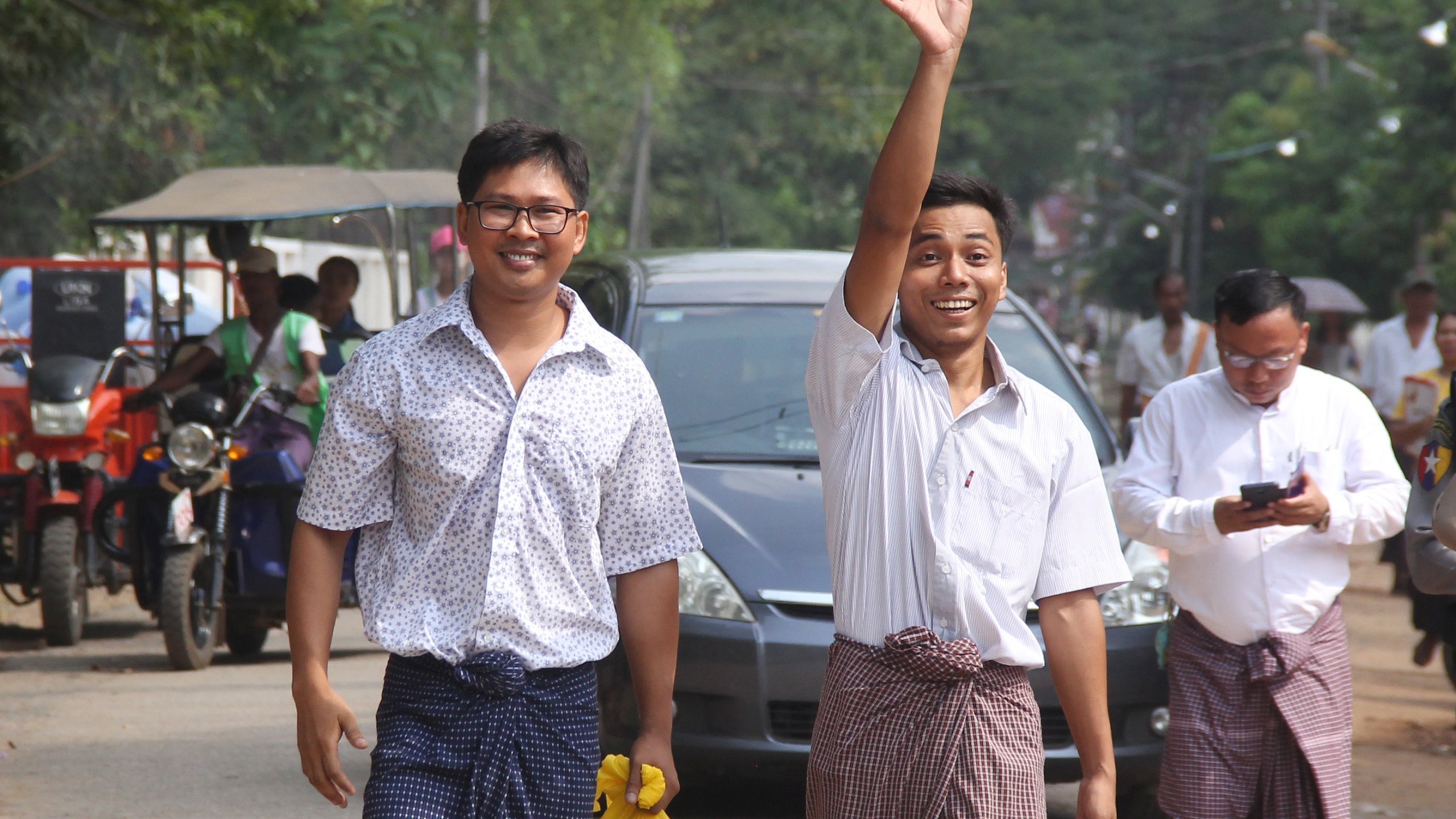 Reuters journalists Kyaw Soe Oo, right, waves beside colleague Wa Lone as they walk out of Insein prison after being freed in a presidential amnesty in Yangon, Myanmar, on May 7, 2019. (Credit: AFP / Getty Images)