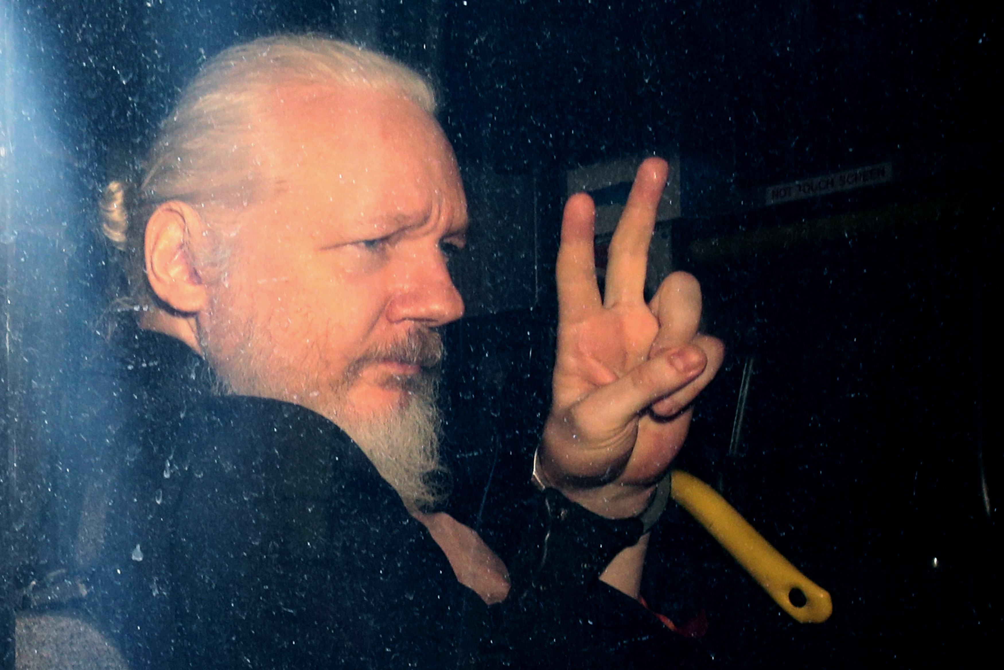 Julian Assange gestures to the media from a police vehicle on his arrival at Westminster Magistrates court on April 11, 2019 in London, England. (Jack Taylor/Getty Images)