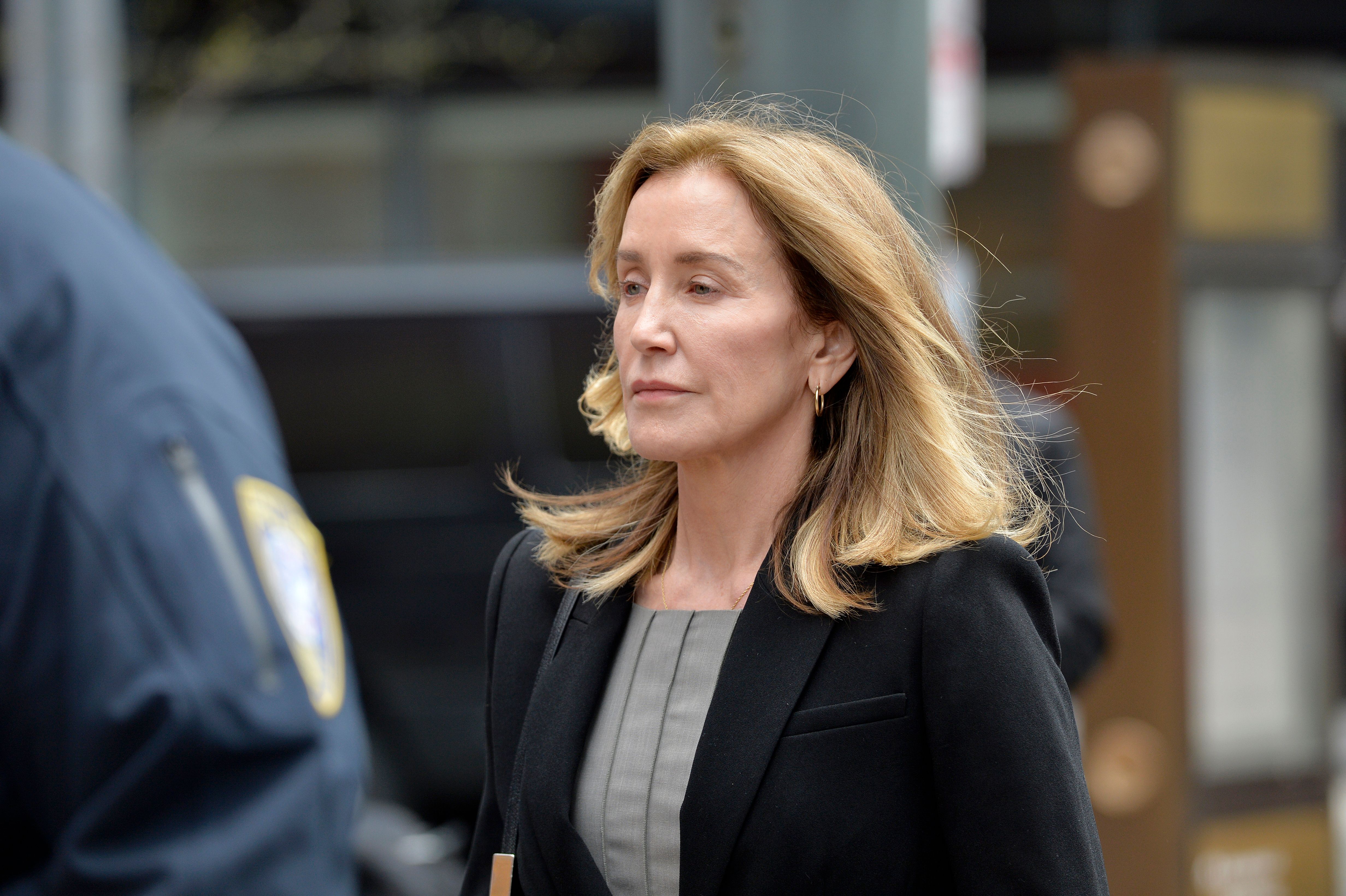 Actress Felicity Huffman is escorted by police into court where she pleaded guilty to one count of conspiracy to commit mail fraud and honest services mail fraud in the college admissions scandal in Boston on May 13, 2019. (Credit: JOSEPH PREZIOSO/AFP/Getty Images)