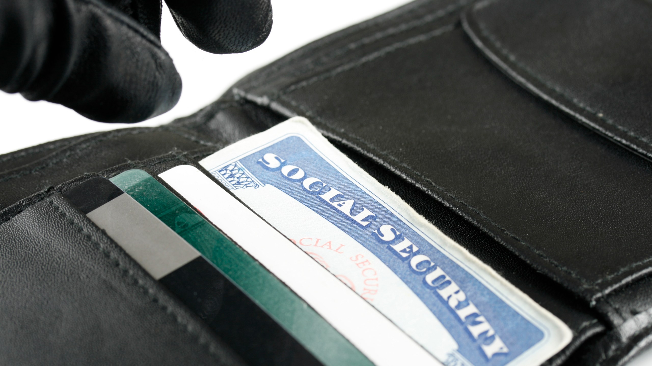 An identity thief's hand is seen reaching for a wallet. (Credit: Getty Images)