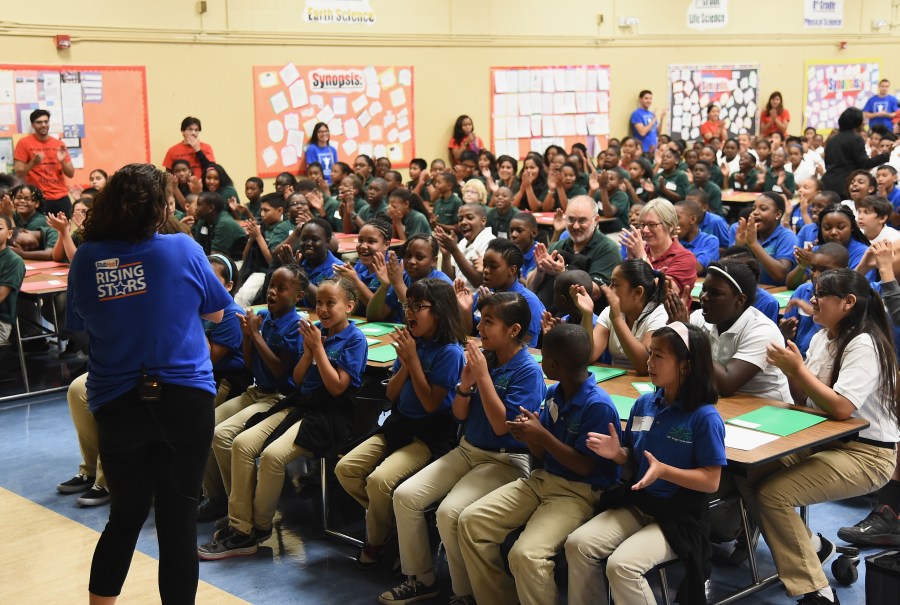 Music teacher Elizabeth Berliant talks with students as StubHub and Mr. Holland's Opus Surprise Bay Area Students with new instruments at KIPP Bridge Charter School on Aug. 12, 2014, in San Francisco. (Credit: Michael Buckner/Getty Images for StubHub)