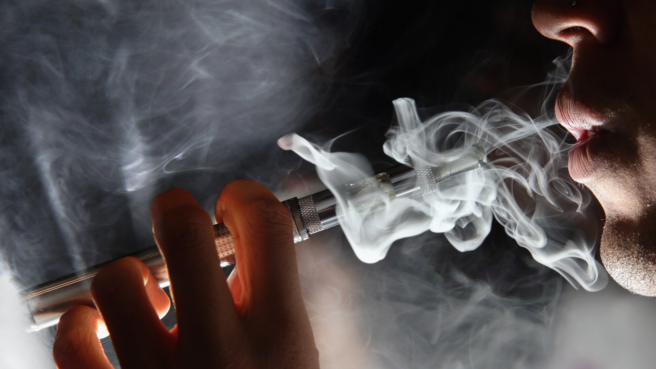 In this photo illustration, a man smokes an e-cigarette at a shop in London on Aug. 27, 2014. (Credit: Dan Kitwood / Getty Images)