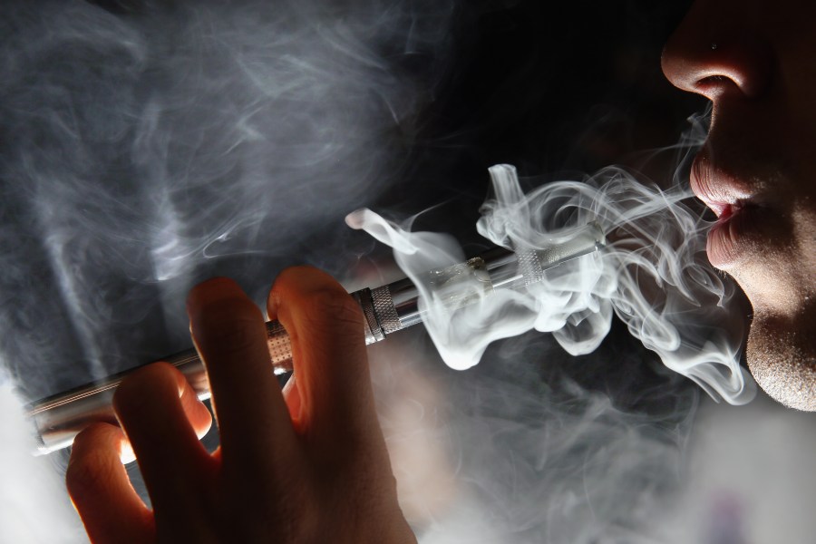 In this photo illustration, a man smokes an e-cigarette at a shop in London on Aug. 27, 2014. (Credit: Dan Kitwood / Getty Images)