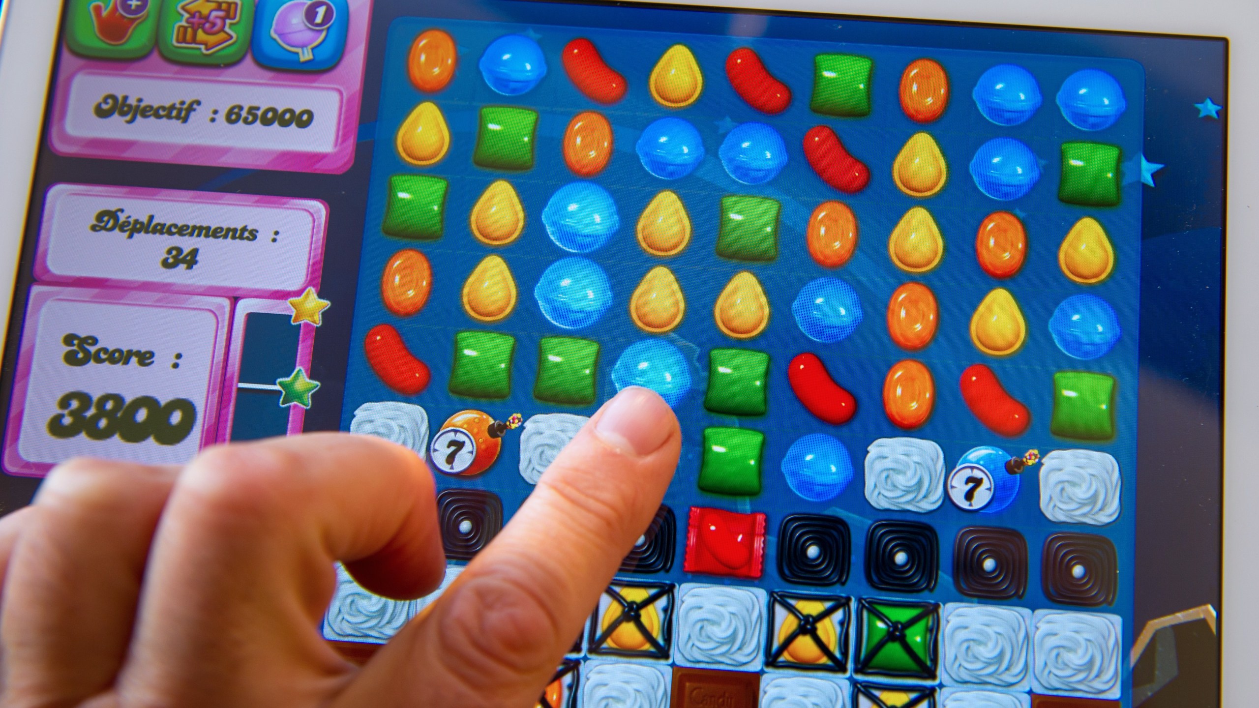 A person plays on his tablet with Candy Crush Saga games developed by British King Digital Entertainment. (Credit: PHILIPPE HUGUEN/AFP/Getty Images)