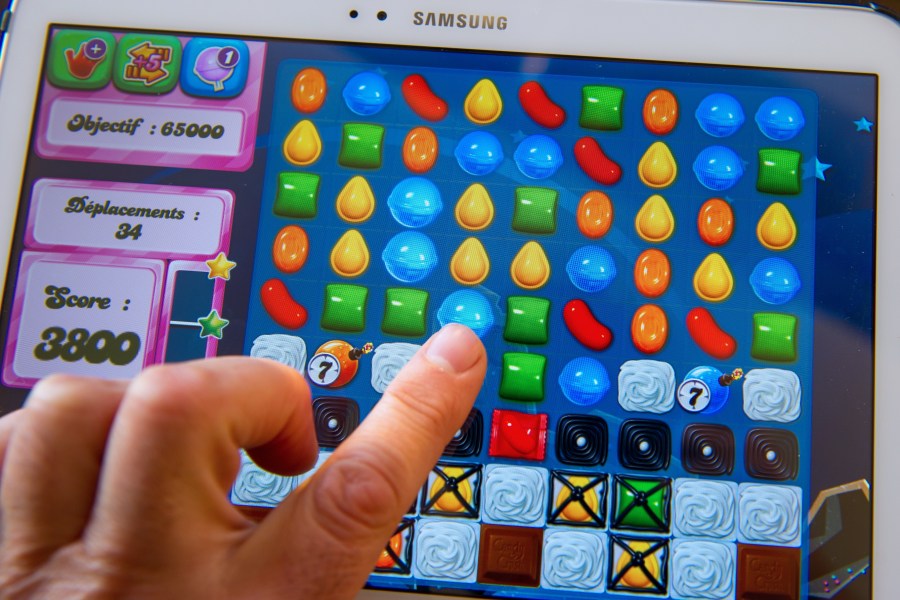 A person plays on his tablet with Candy Crush Saga games developed by British King Digital Entertainment. (Credit: PHILIPPE HUGUEN/AFP/Getty Images)