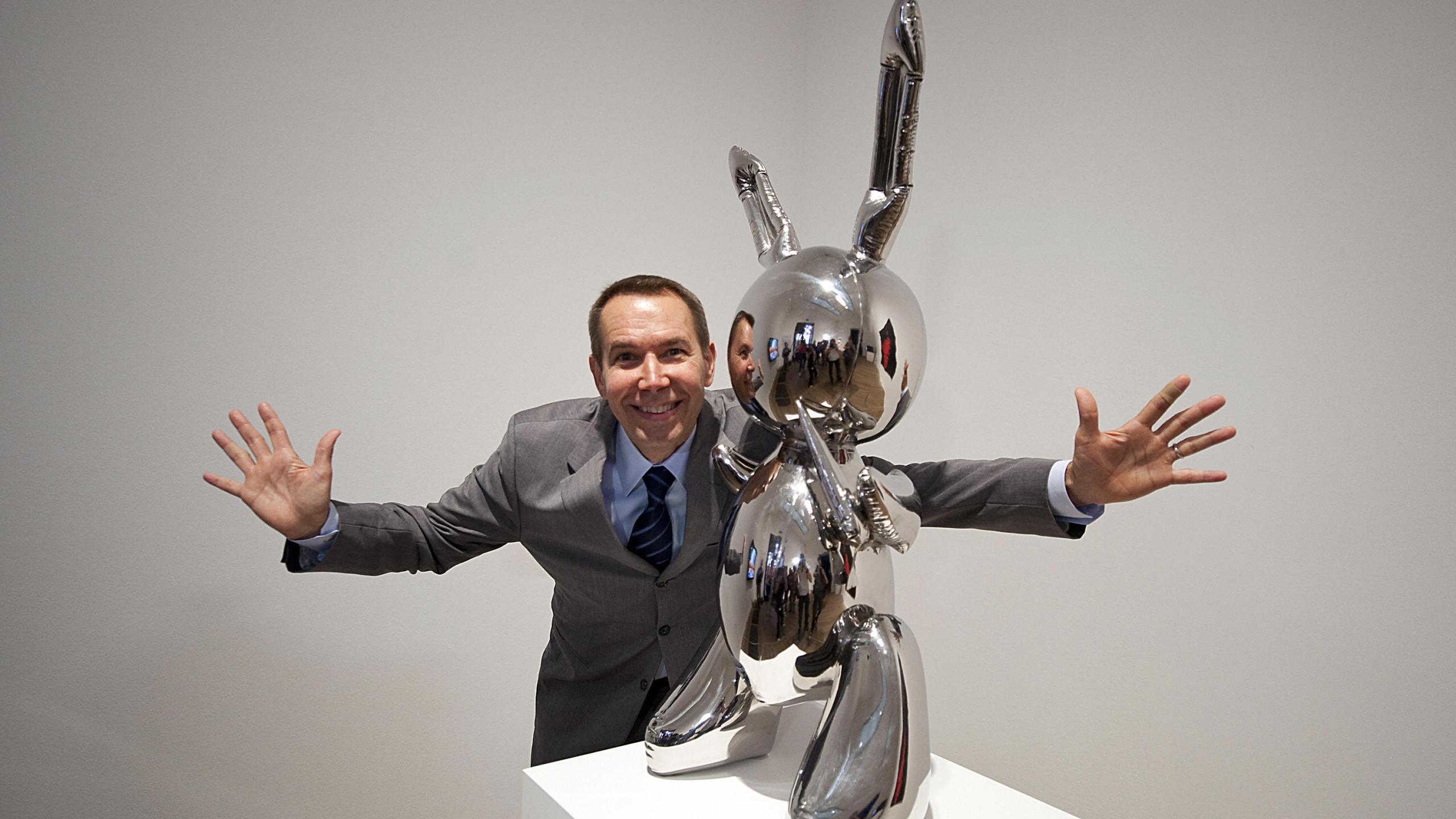 Artist Jeff Koons poses for photographs with his work of art entitled 'Rabbit 1986' during the press view of the 'Pop Life, Art In A Material World' exhibition at the Tate Modern, in London, on September 29, 2009. (Credit: BEN STANSALL/AFP/Getty Images)