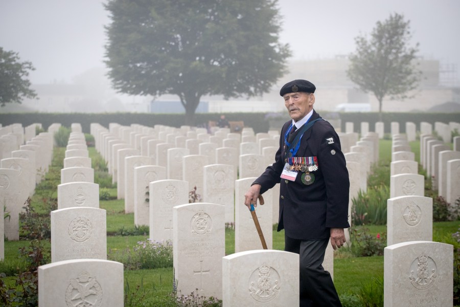 Normany veteran 98-year-old Edwin 'Ted' Hunt walks past the graves of the fallen as Normandy veterans attend a official service of remembrance at Bayeux Cemetery during the D-Day 74th anniversary commemorations in Normandy on June 6, 2018 in Bayeux, France. (Credit: Matt Cardy/Getty Images)