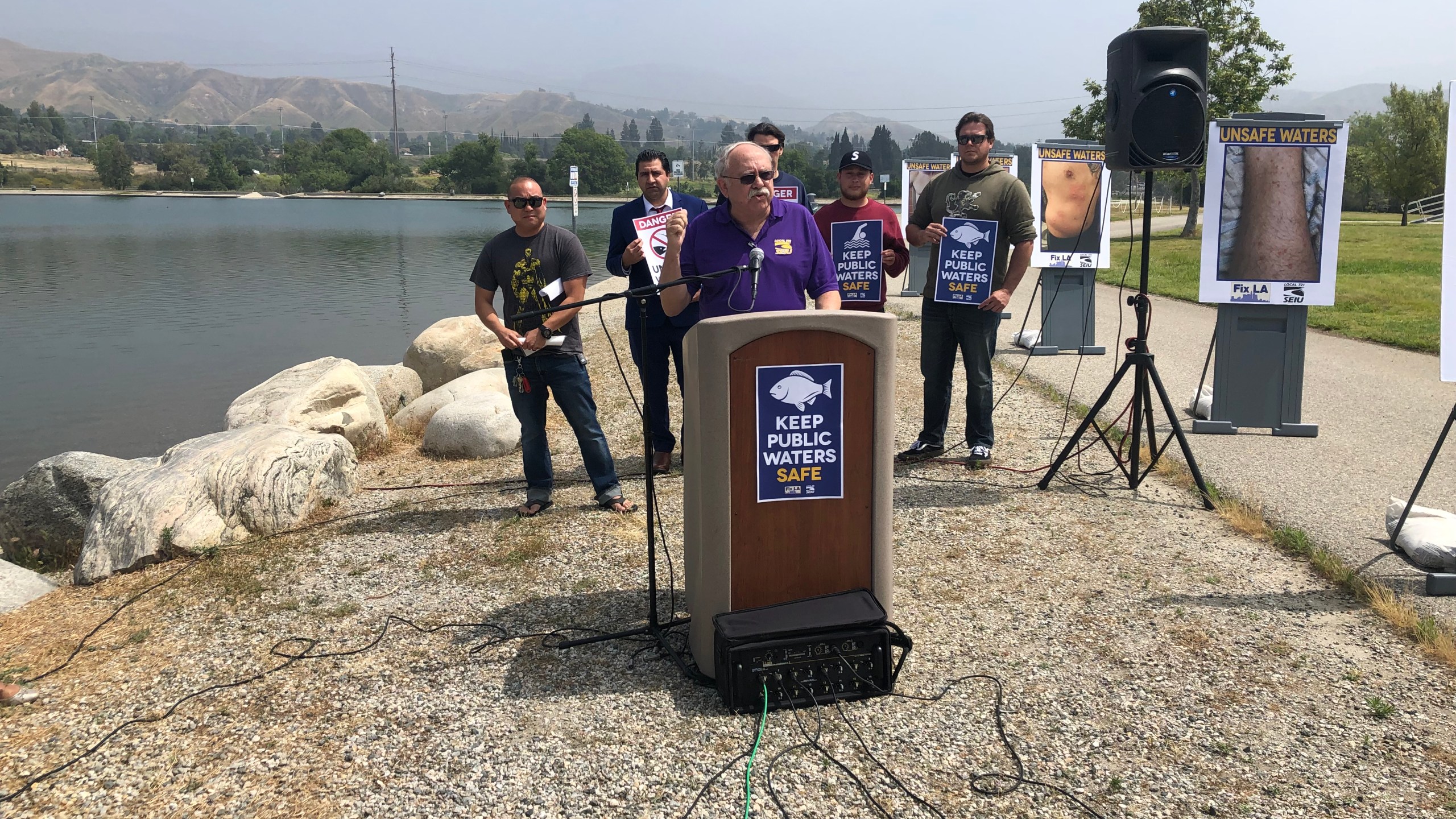 Los Angeles city lifeguards and San Fernando Valley community leaders hold a press conference to discuss concerns over water quality at the Hansen Dam Recreation Lake on May 14, 2019. (Credit: KTLA)