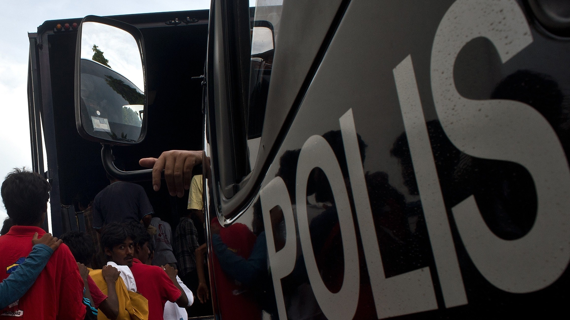 Bangladeshi migrants board a police van at the police headquarters in Langkawi on May 11, 2015. (Credit: MANAN VATSYAYANA/AFP/Getty Images)