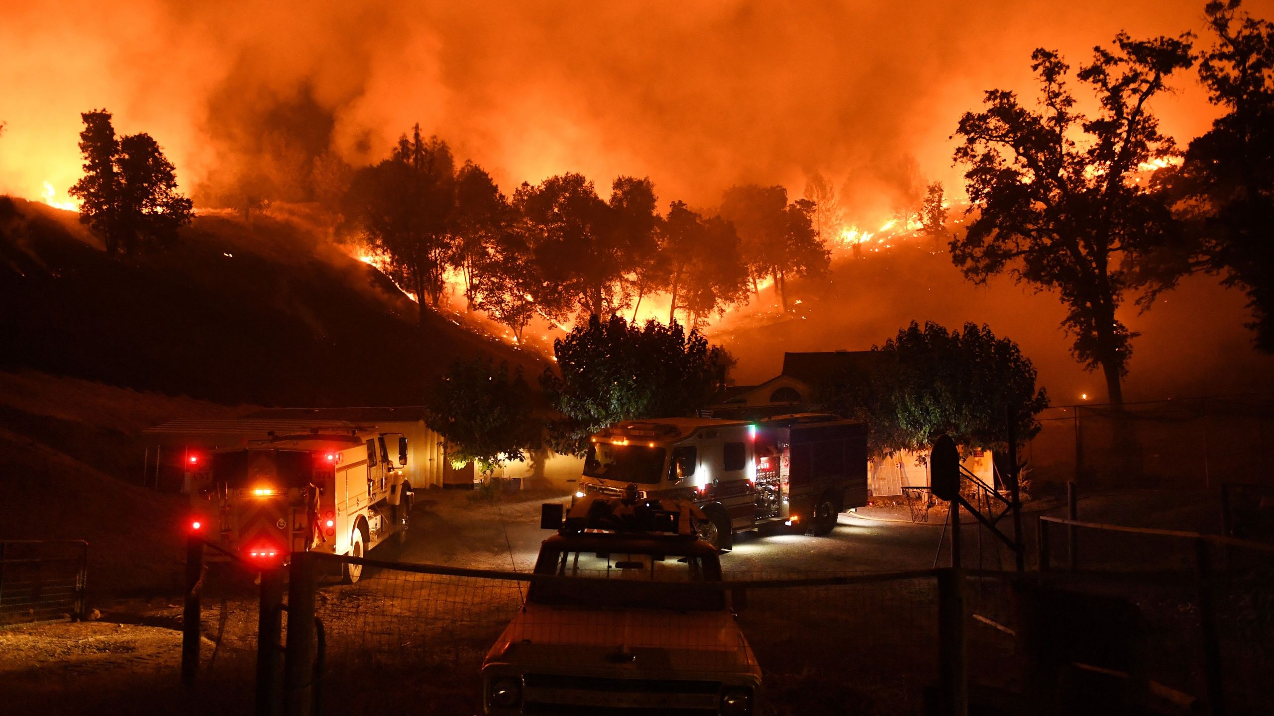 Firefighters conduct a controlled burn to defend houses against flames from the Ranch Fire, part of the Mendocino Complex Fire, as it continues to spread toward the town of Upper Lake on Aug. 2, 2018. (Credit: Mark Ralston / AFP / Getty Images)