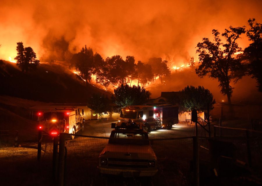 Firefighters conduct a controlled burn to defend houses against flames from the Ranch Fire, part of the Mendocino Complex Fire, as it continues to spread toward the town of Upper Lake on Aug. 2, 2018. (Credit: Mark Ralston / AFP / Getty Images)