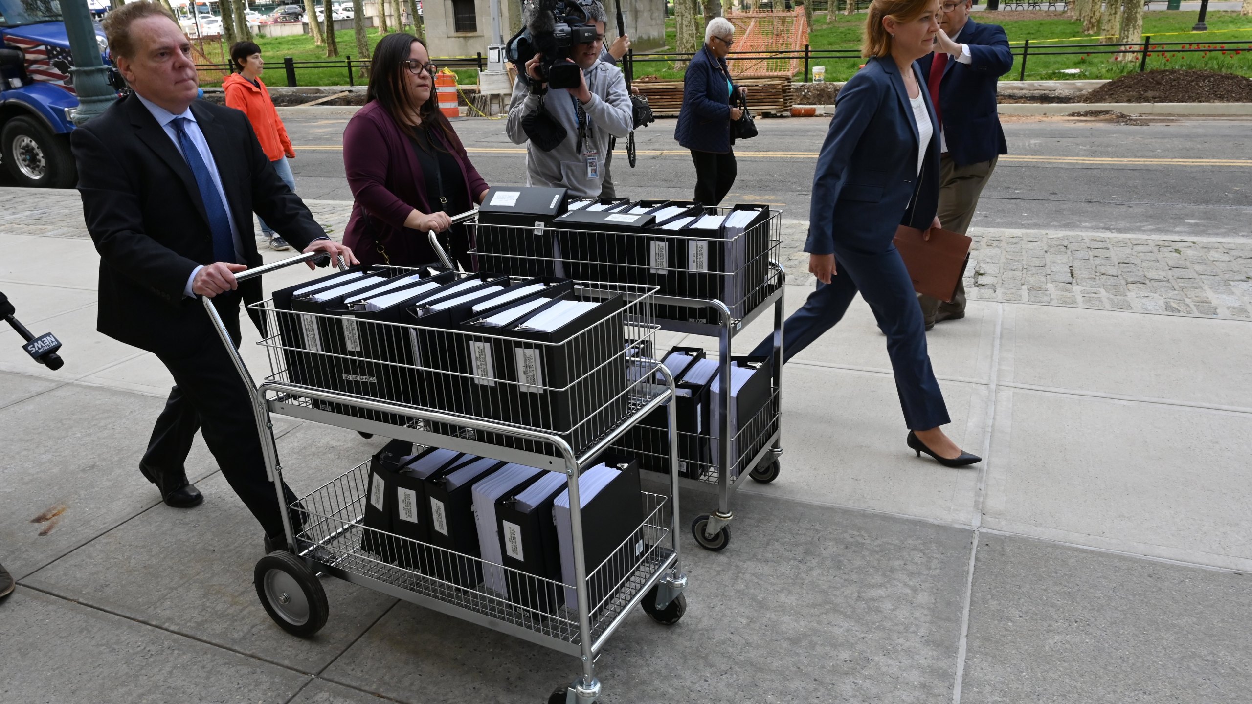 Members of the prosecution in the Nxivm case arrive with documents at Brooklyn Federal Court on May 7, 2019, for day one of the trial of Keith Raniere, founder of Nxivm. (Credit: TIMOTHY A. CLARY/AFP/Getty Images)