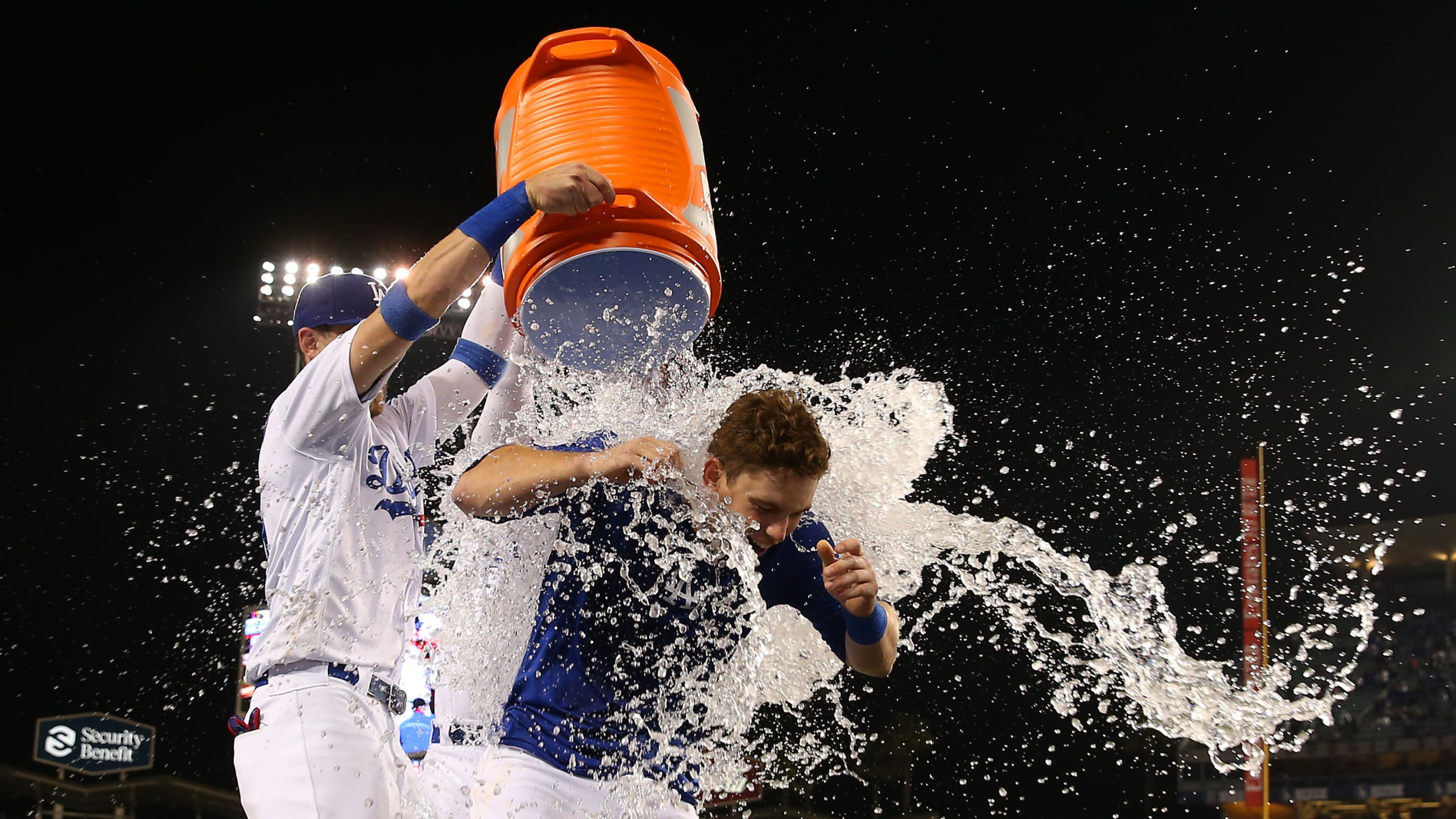 Will Smith #16 of the Los Angeles Dodgers is doused with a bucket of water by teammates Cody Bellinger #35 and Joc Pederson #31 after Smith hit a walk-off home run in the ninth inning of the MLB game against the Philadelphia Phillies at Dodger Stadium on June 01, 2019/ (Credit: Victor Decolongon/Getty Images)