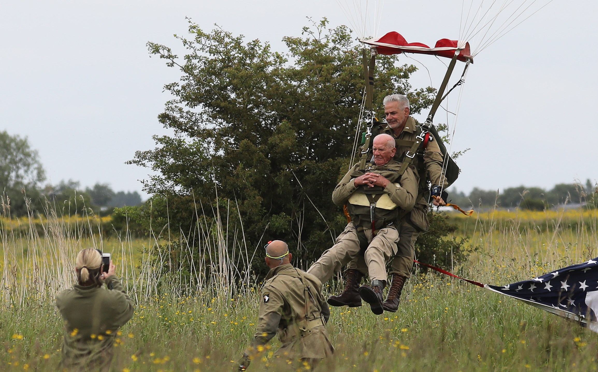 WWII veteran Tom Rice of San Diego, front, lands as he takes part in a parachute drop over Carentan, Normandy, on June 5, 2019, as part of D-Day commemorations marking the 75th anniversary of the World War II Allied landings in Normandy. (Credit: Ludovic Marin / AFP / Getty Images)