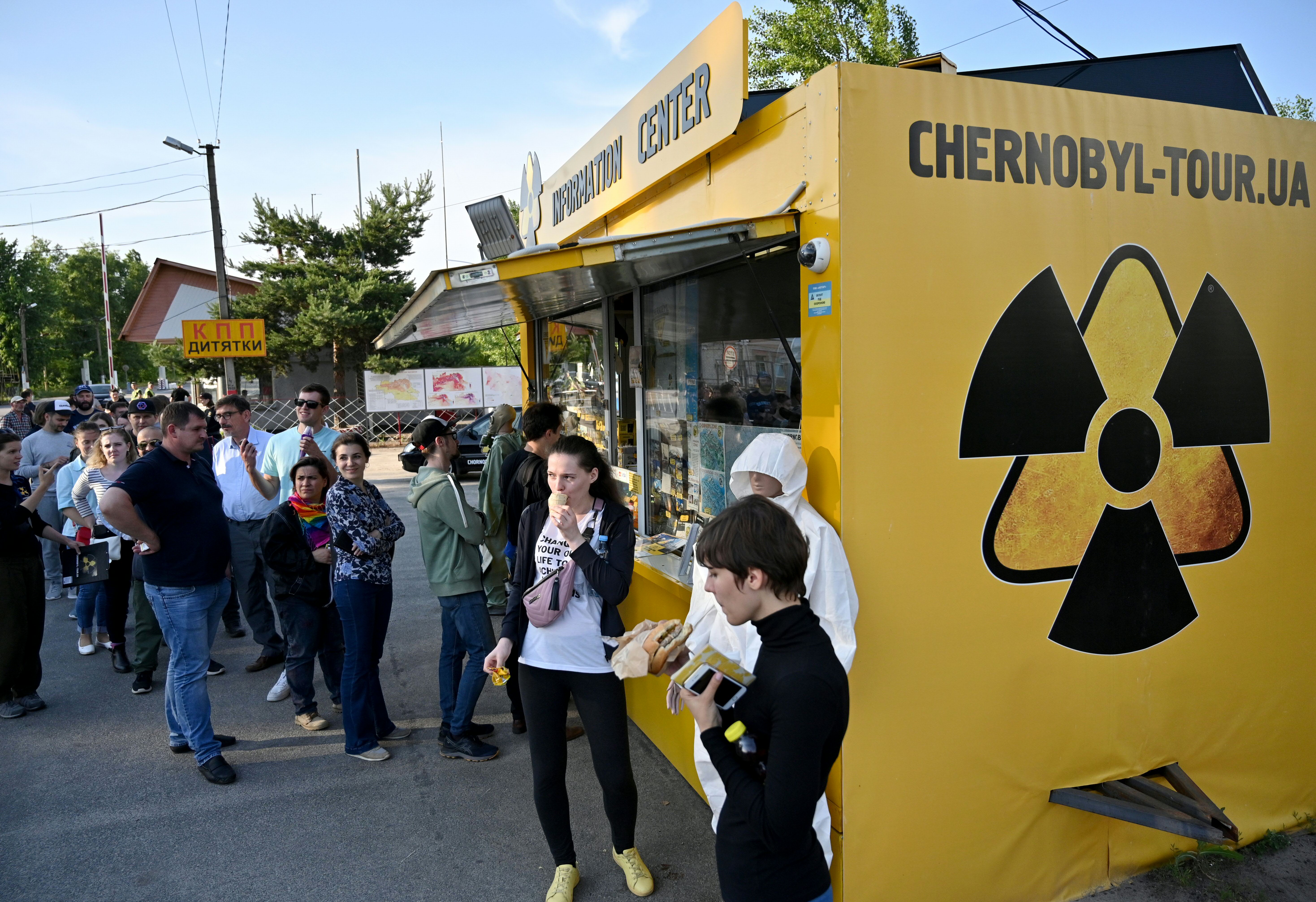 Visitors wait in line to buy snacks and souvenirs at a souvenir shop next to the Dytyatky checkpoint after a tour in the Chernobyl exclusion zone on June 7, 2019. (Credit: GENYA SAVILOV/AFP/Getty Images)