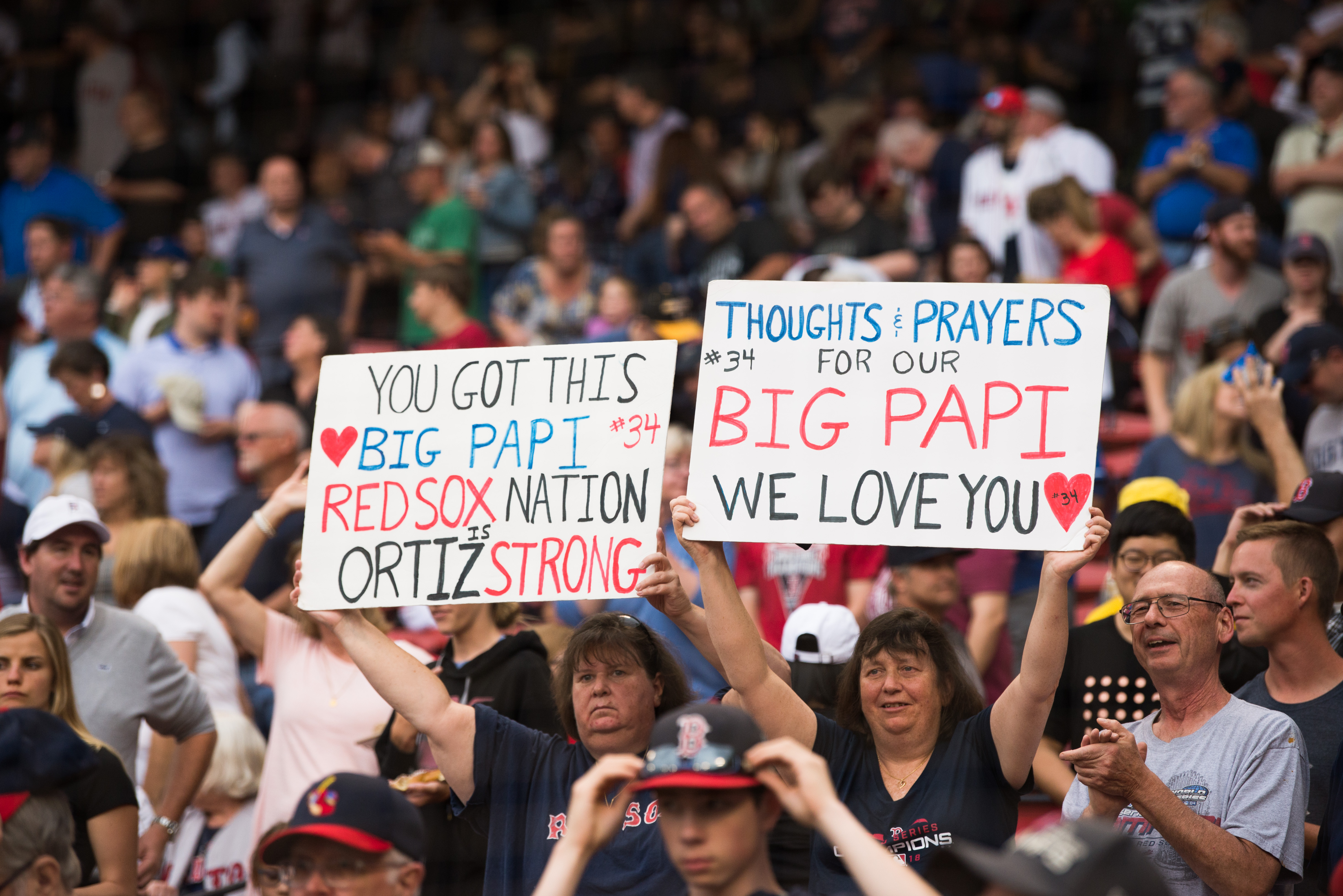 Fans hold up signs showing support for former Red Sox player David Ortiz prior to the start of the game against the Texas Rangers at Fenway Park on June 10, 2019 in Boston, Massachusetts. (Credit: Kathryn Riley /Getty Images)