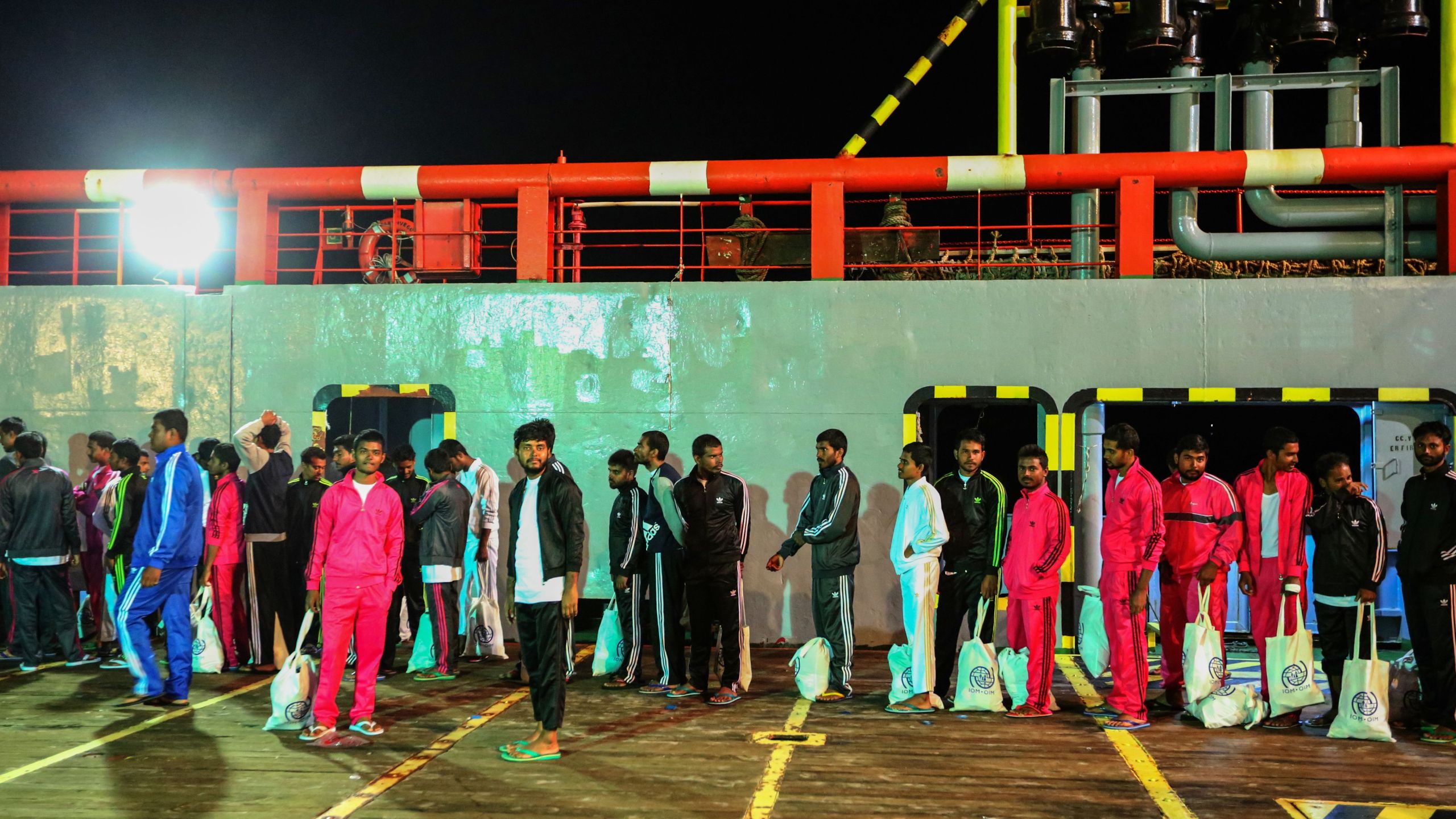 Migrants walk along the dock after disembarking from a vessel as ay arrive to Zarzis harbour in a souarn coast of Tunisia on June 18, 2019. (Credit: FATHI NASRI/AFP/Getty Images)